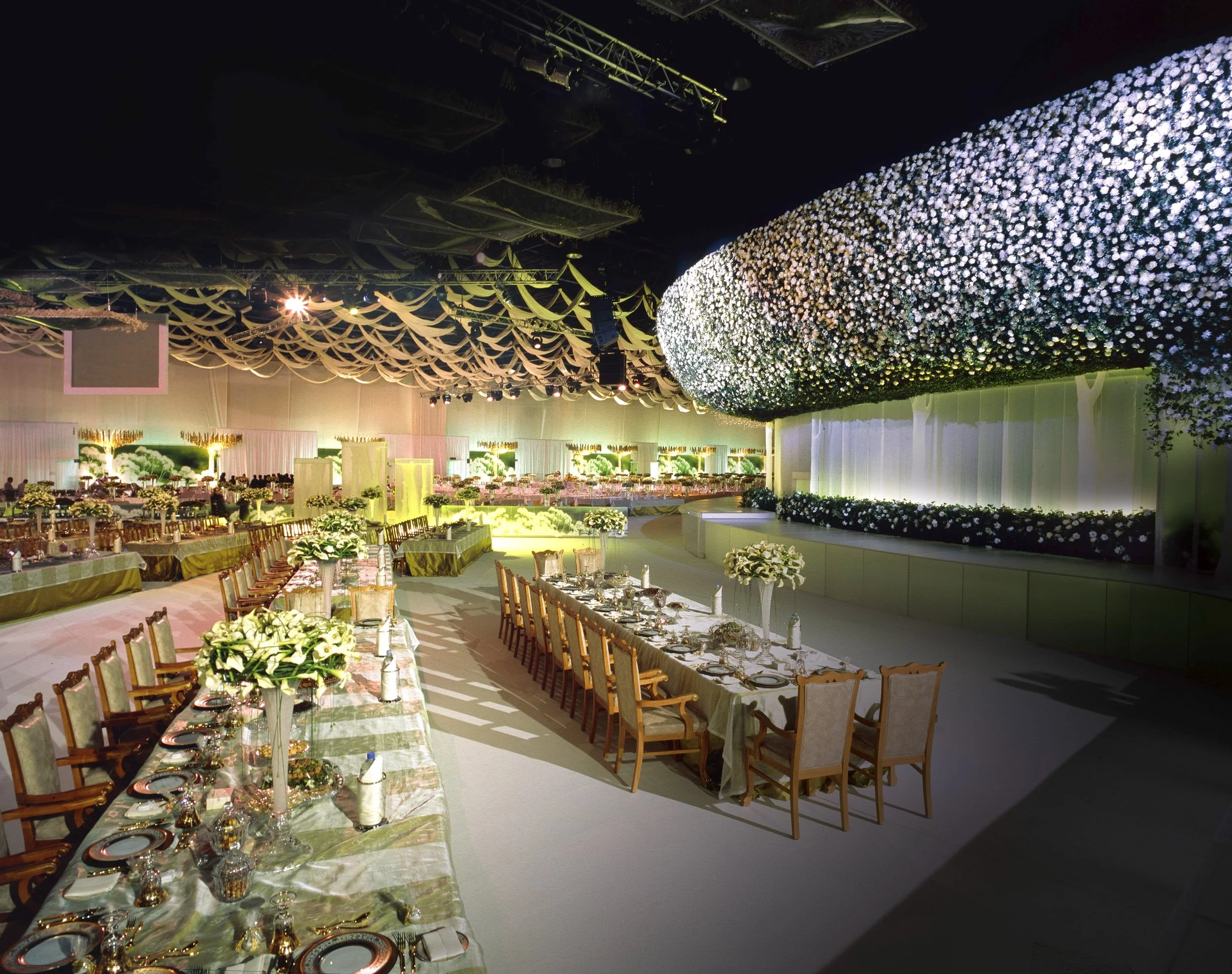 Grand wedding banquet with sculptural white floral ceiling installation and long luxury dining tables by Daniel Ost.