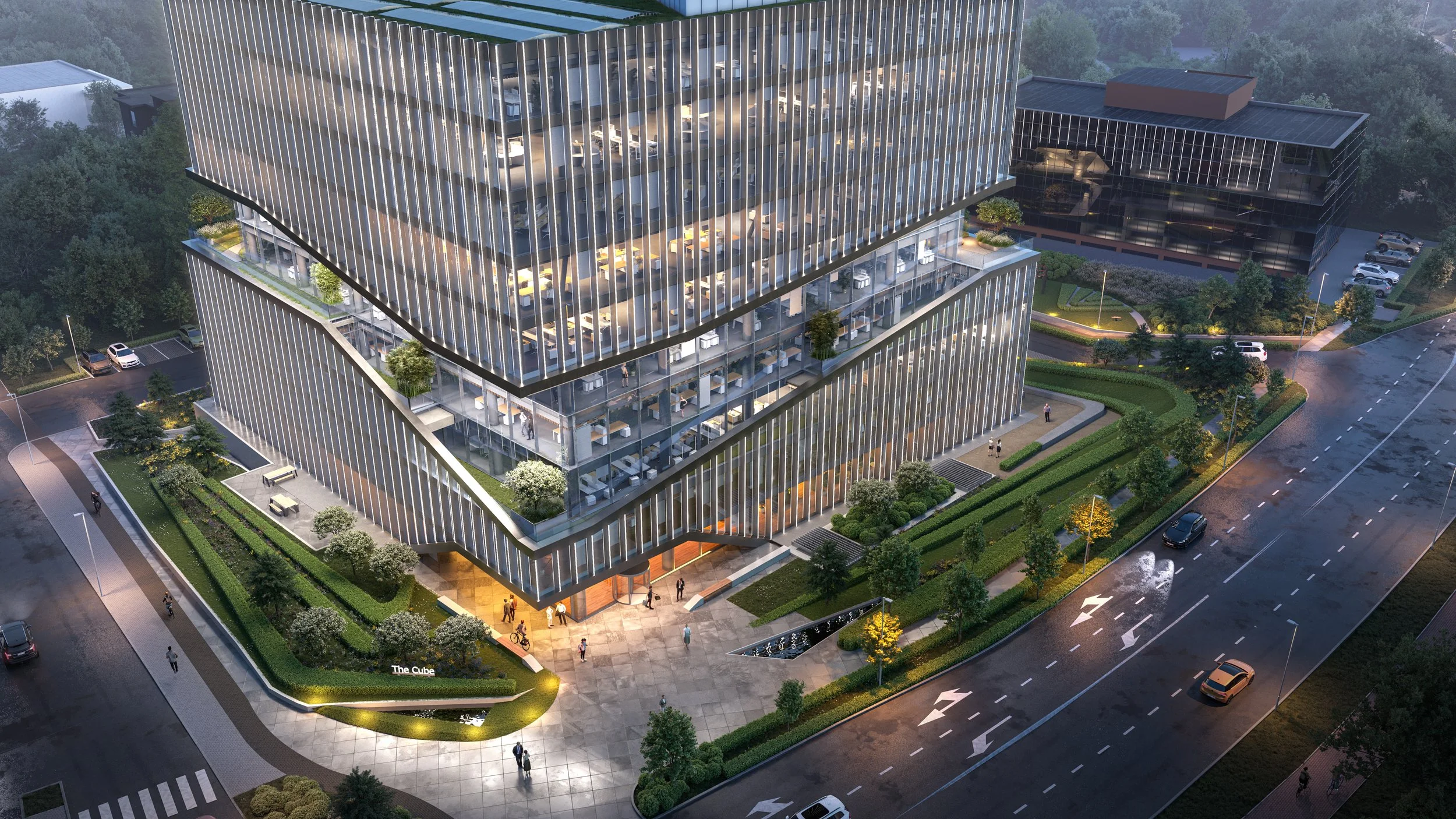 Corporate headquarters with landscaped gardens, tiered green terraces, and illuminated modern architecture viewed from above.