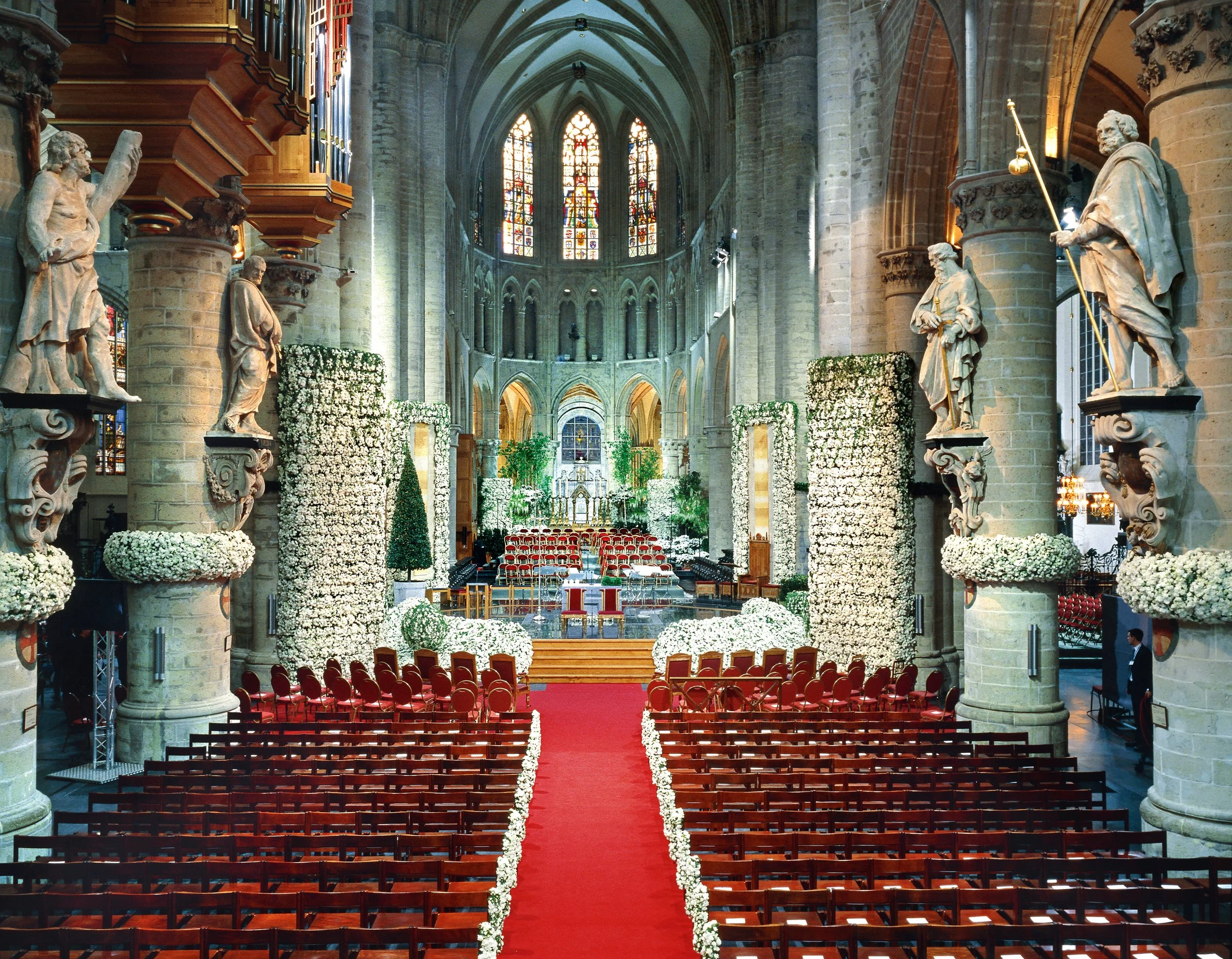 Royal cathedral wedding ceremony with monumental floral columns of white roses decorating the nave and altar.