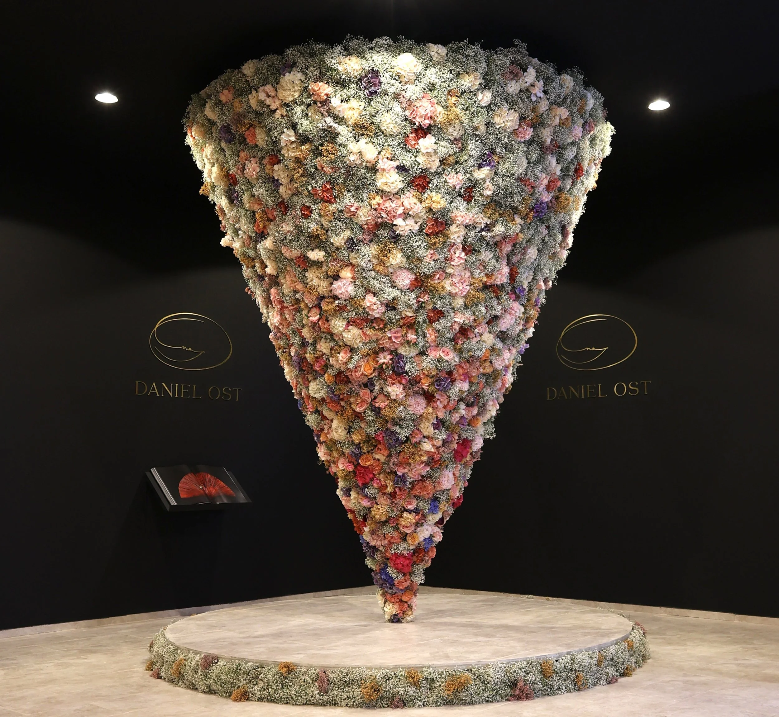 Floral art installation with inverted cone of roses and gypsophila, creating a striking hospitality and lifestyle exhibition piece.
