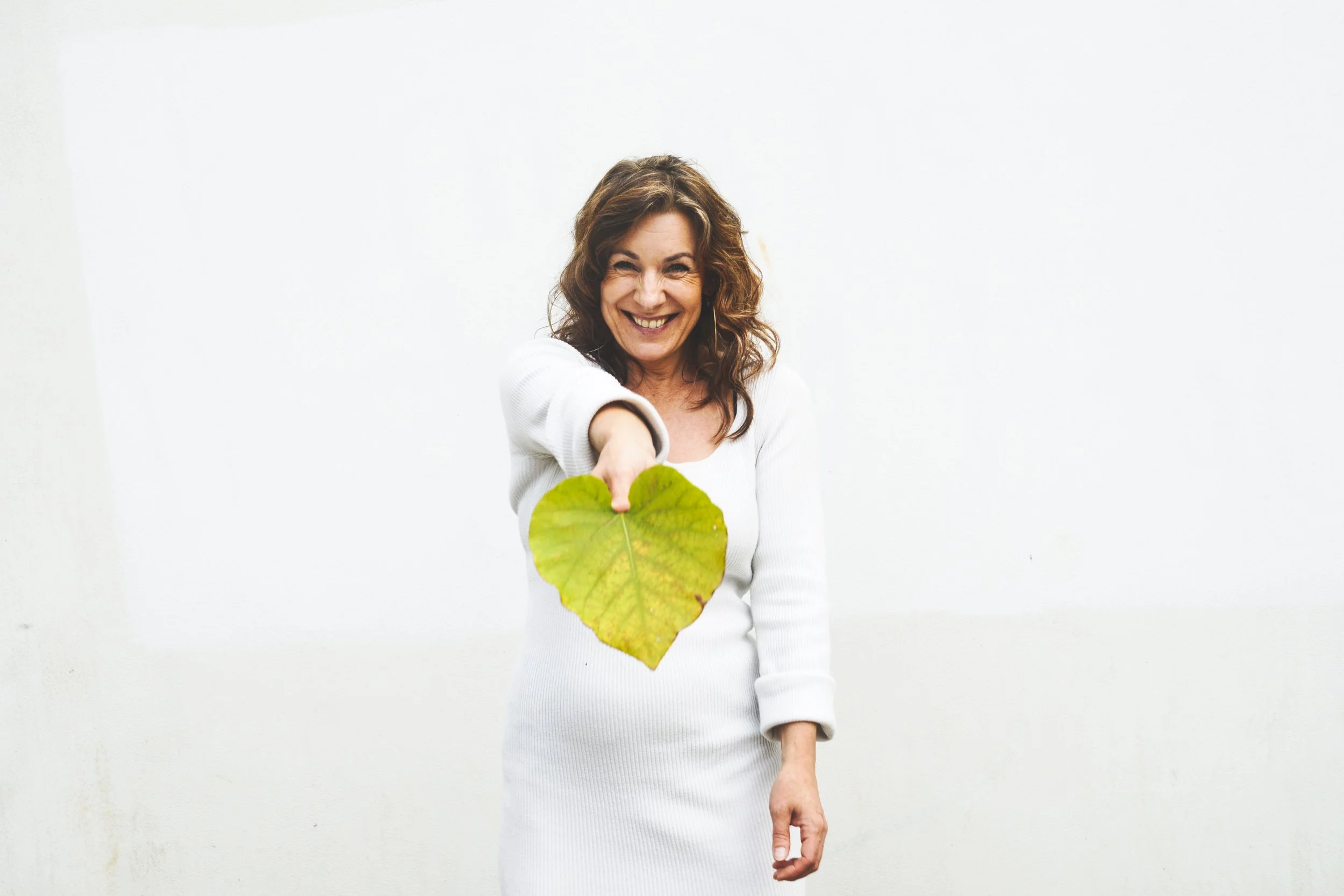 Frederikke Darkner holding a green heart-shaped leaf, symbolising calm and care at KESH.