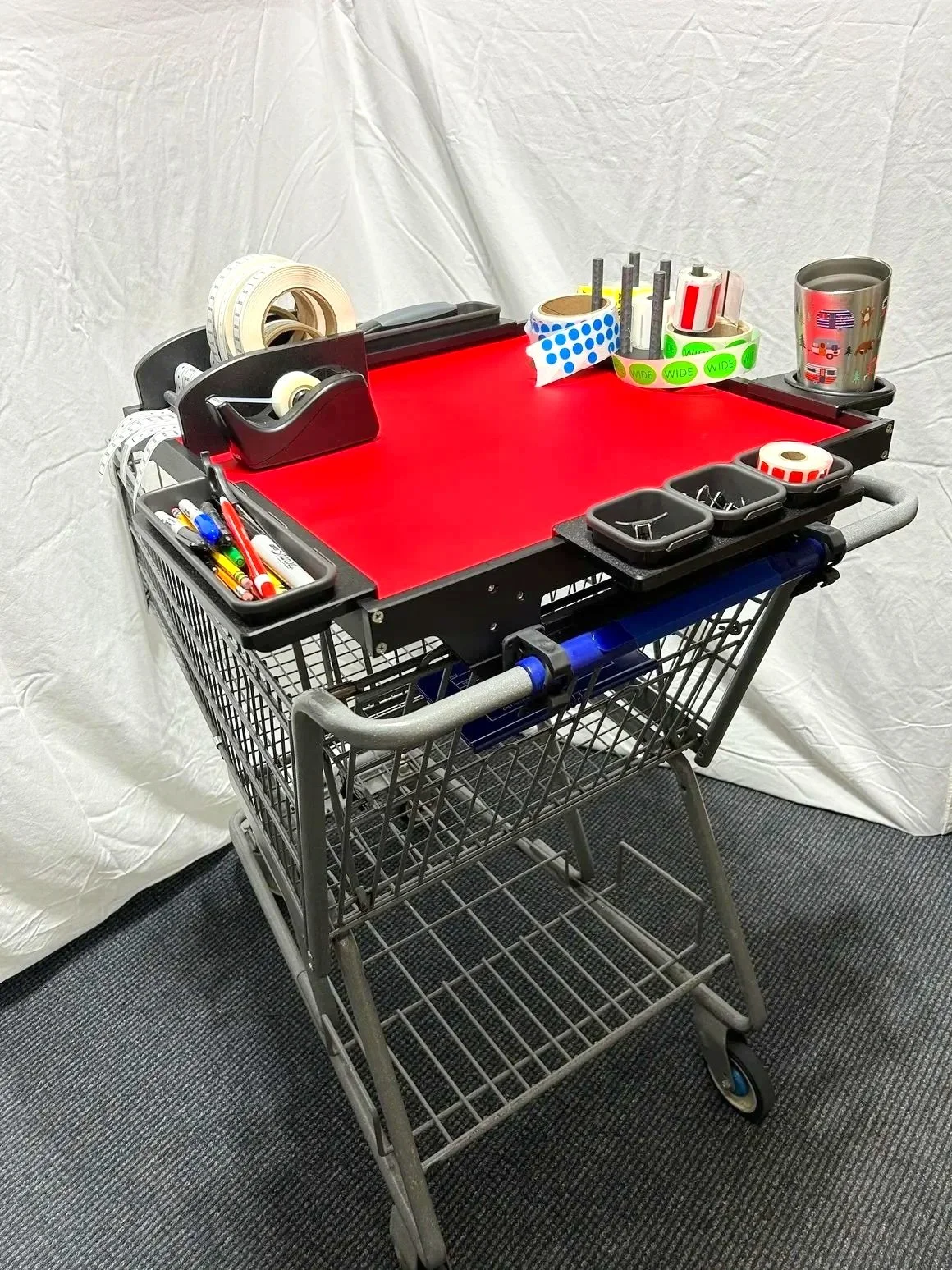 The HandyCart Workstation™ with red tabletop holding retail tools for merchandising efficiency.