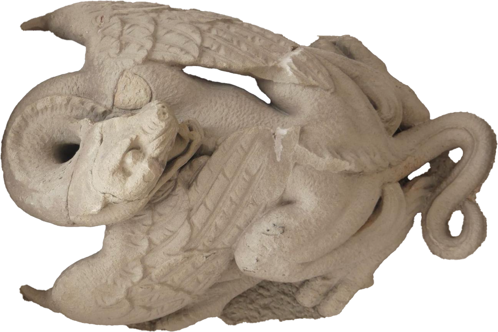 A carved stone sculpture of a ram's head with detailed curved horns, textured fur, and an ornate design.