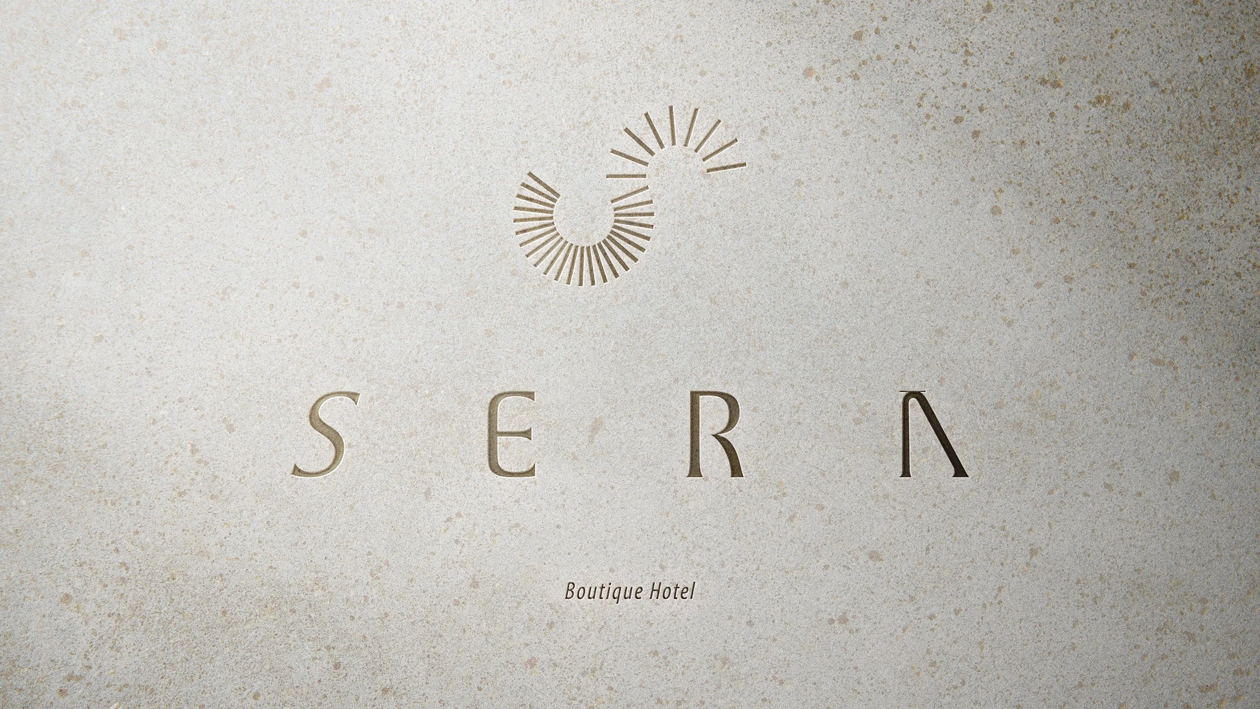 Front of a hotel with the words "Serra Boutique Hotel" on a textured beige wall, with a circular logo above the text.