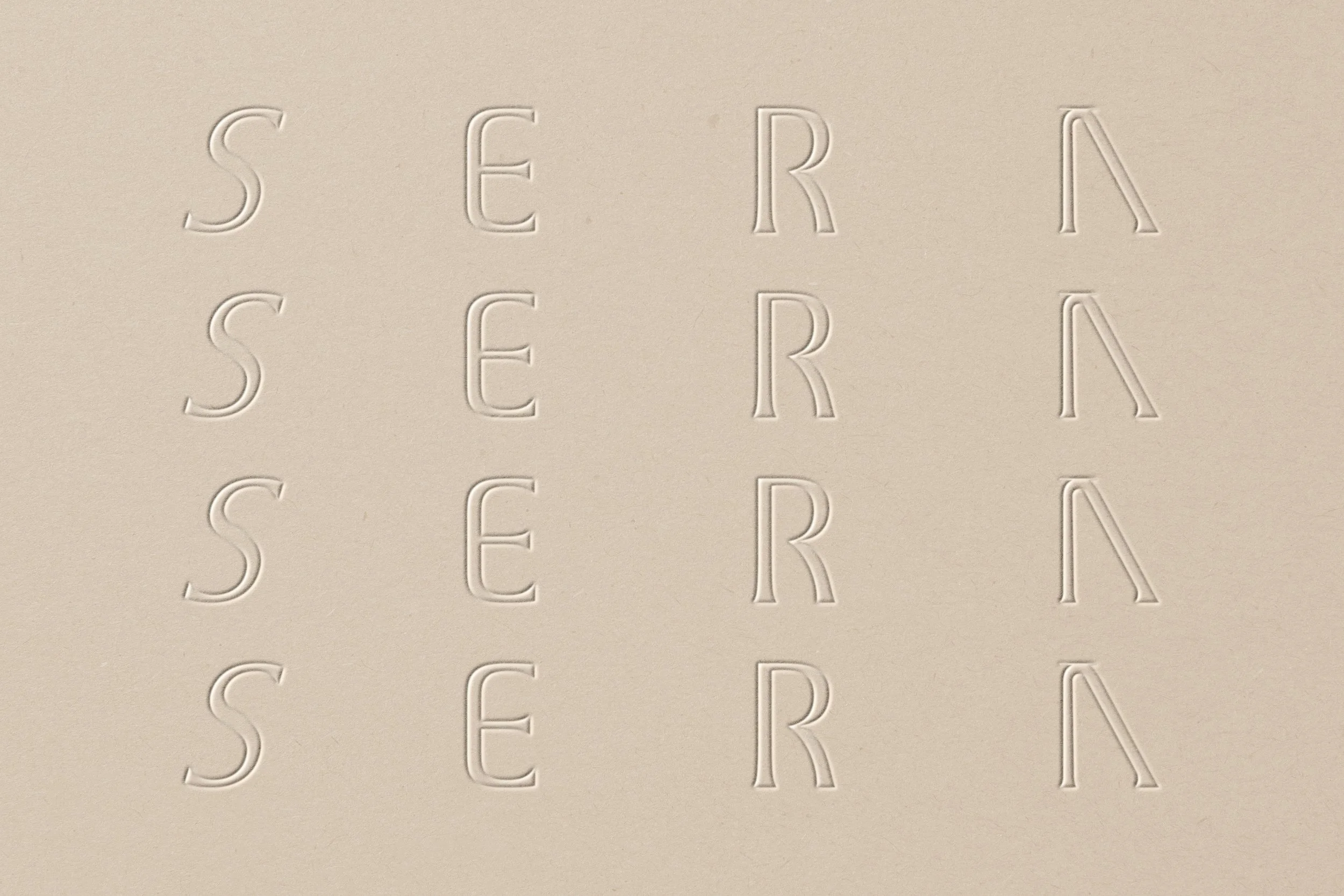 Embossed words on a beige surface spelling out 'S E R A'.