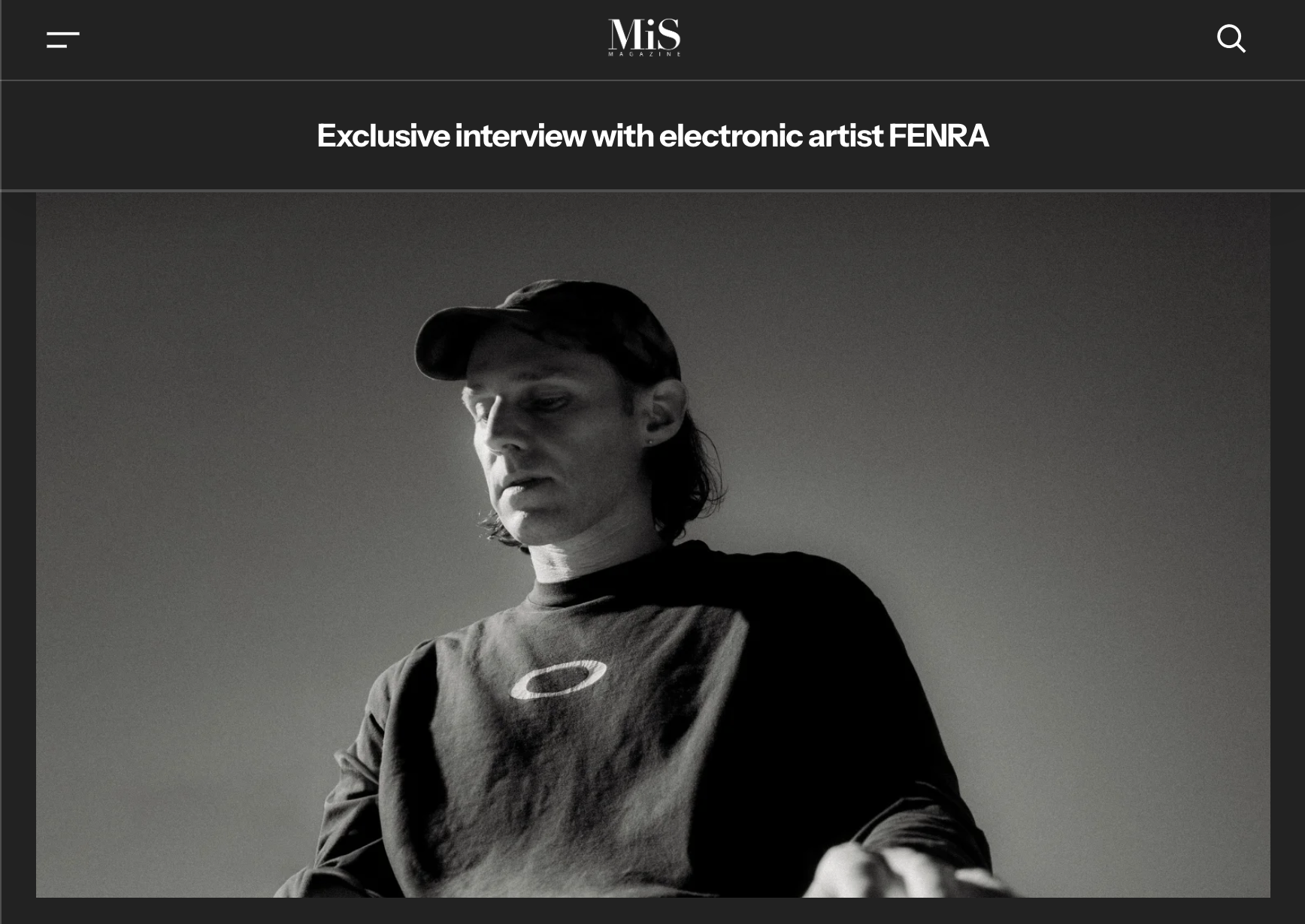 Webpage image of Shoreditch Magazine showing electronic musician and producer, FENRA, standing in a photo studio standing in a dark, Oakley shirt and cap.