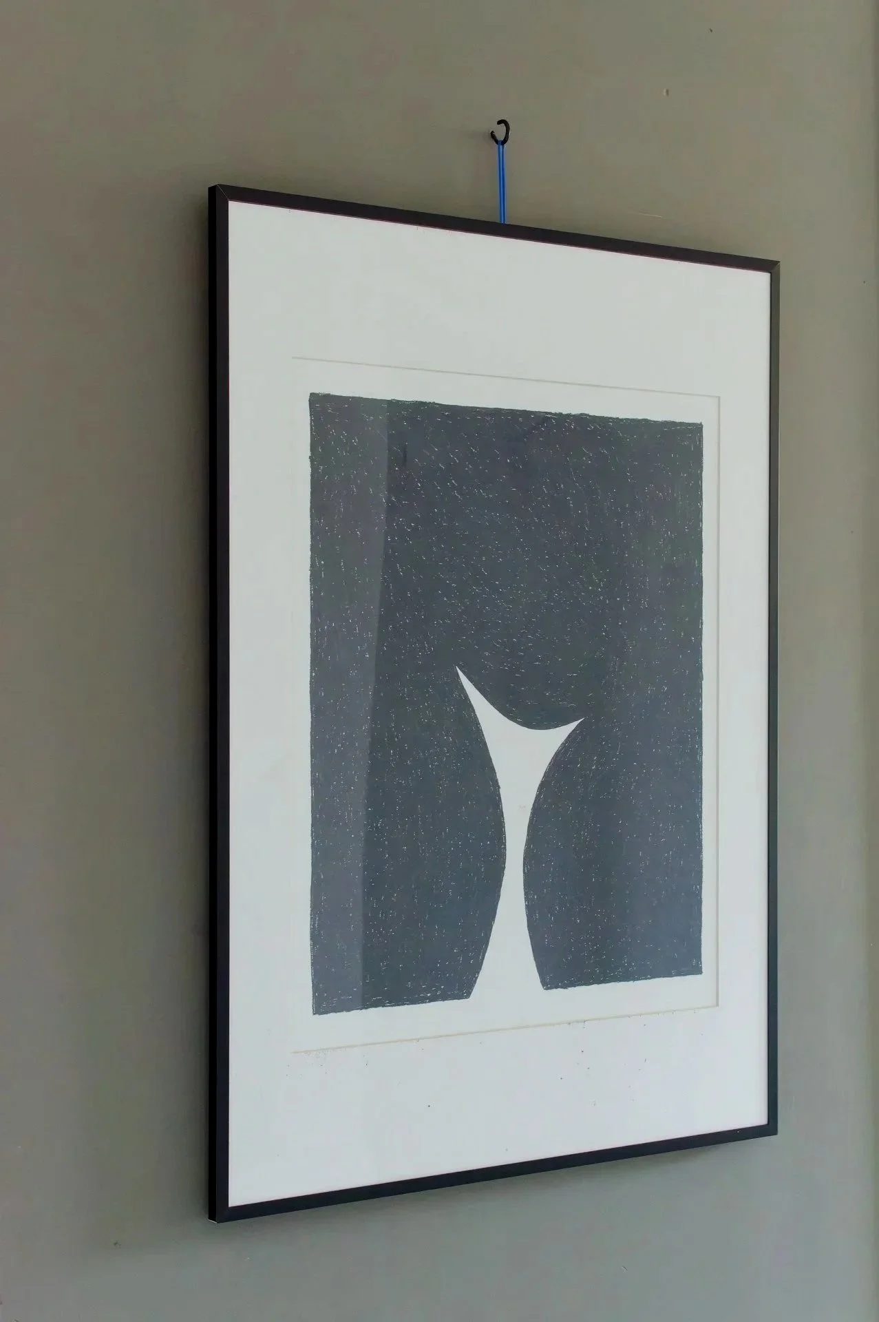 Framed abstract black and white artwork of a person's buttocks viewed from behind, hanging on a wall.
