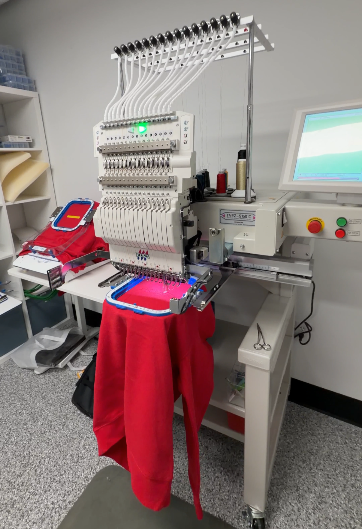 Custom sweater being embroidered in a custom apparel shop.
