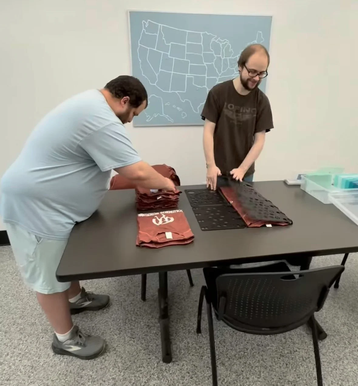 Team at The Awesome Company folding and packaging printed shirts.