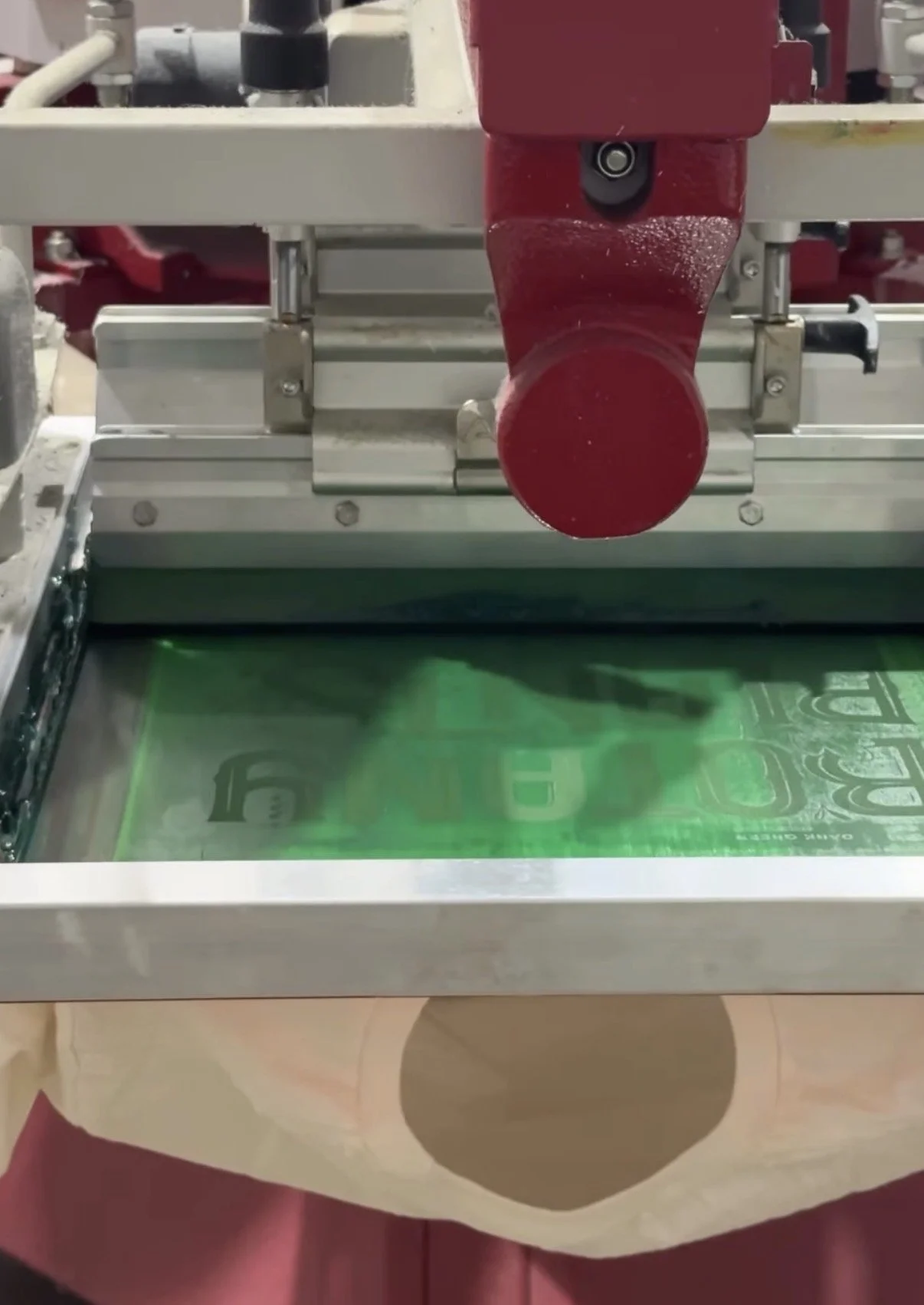 Custom apparel production floor with garments in progress being screen printed.