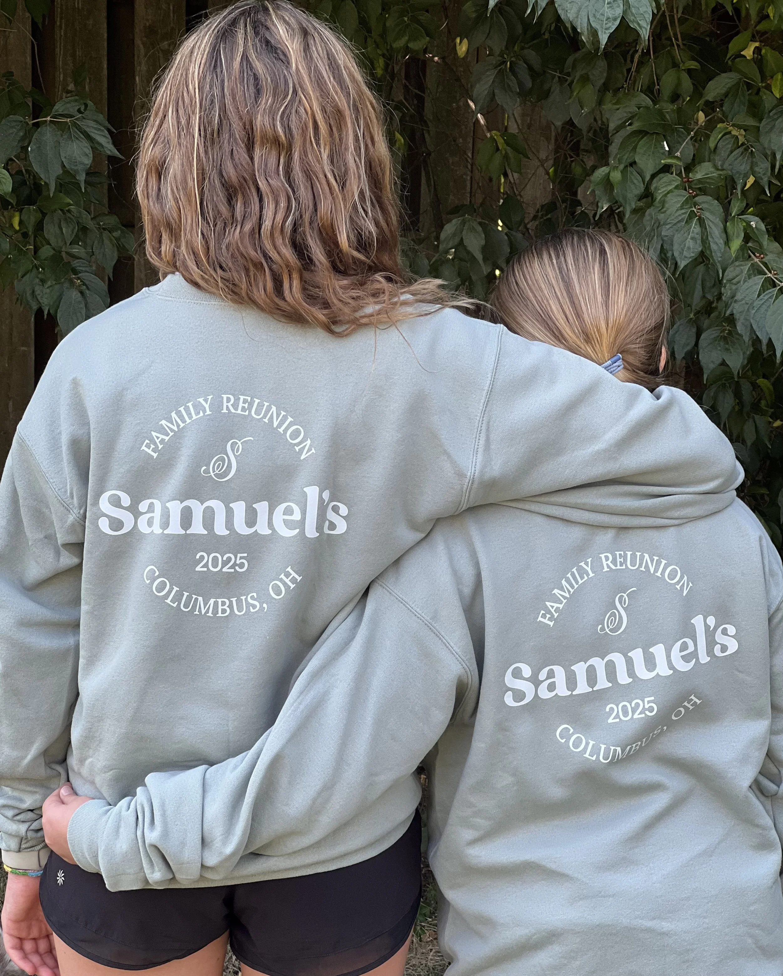 Two sisters wearing matching family reunion sweaters.