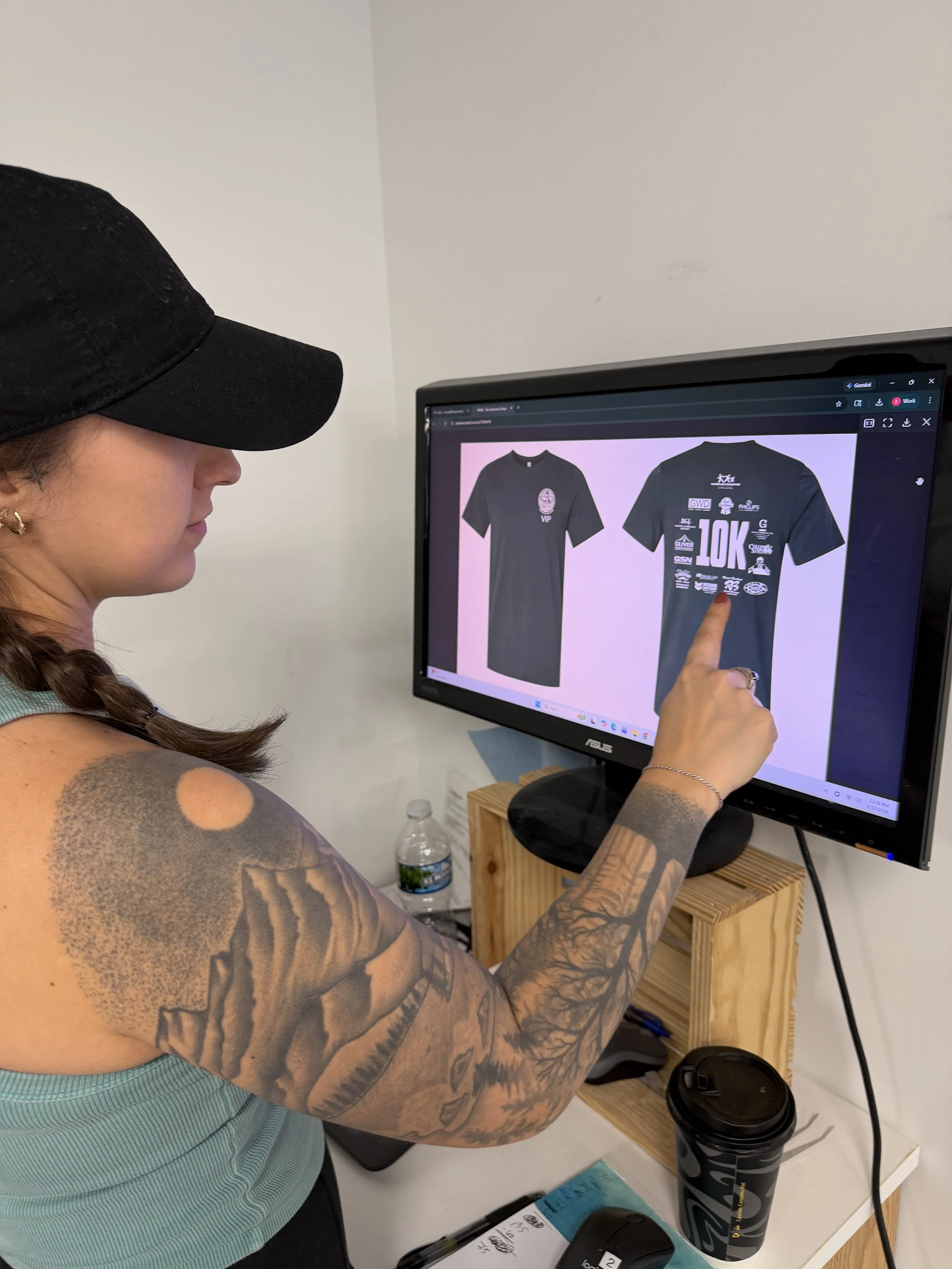 Designer working on custom shirt artwork on a computer.