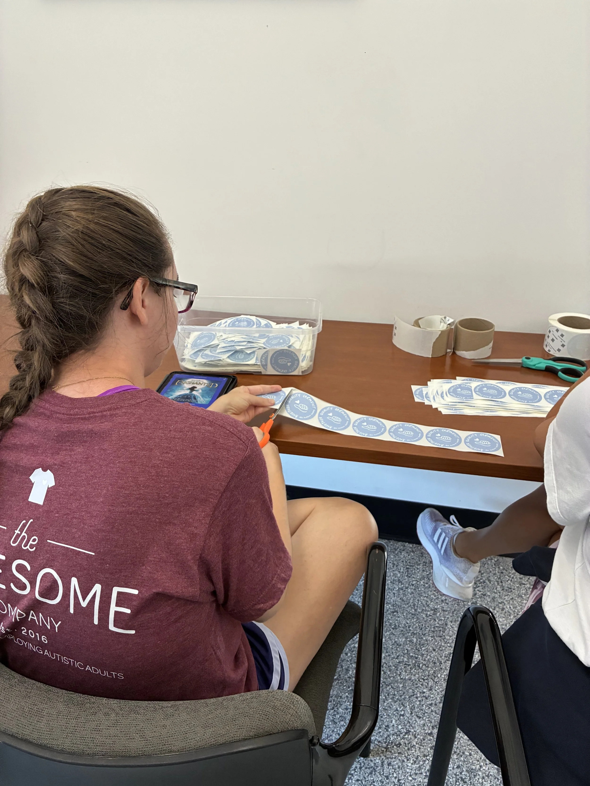 Autistic employee working confidently at a work station in a calm print shop.