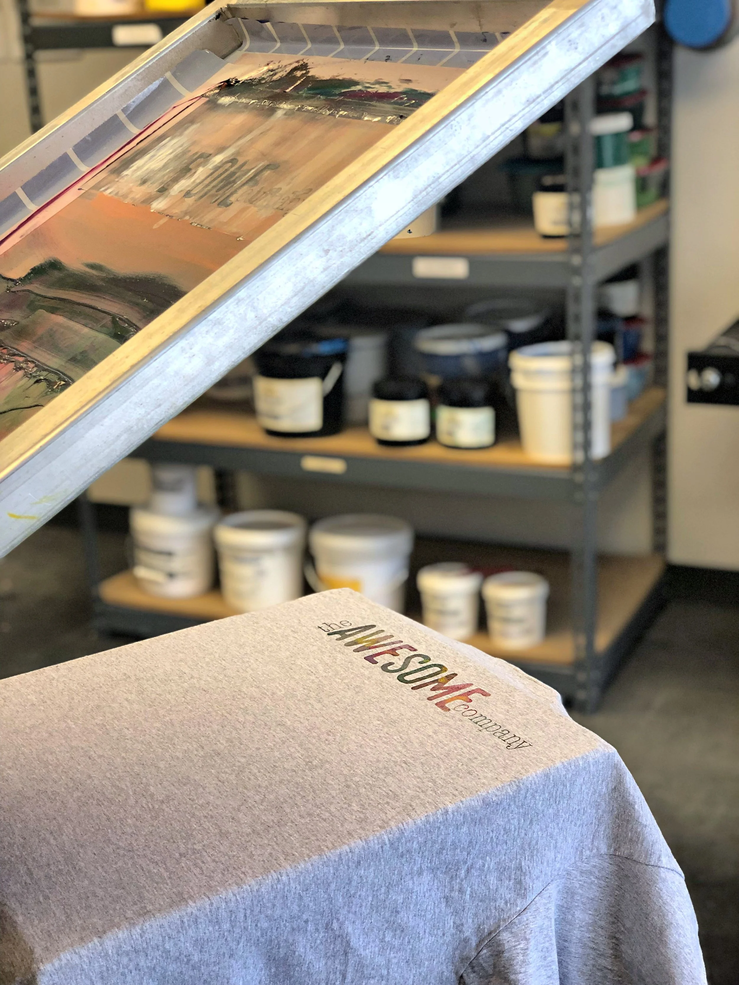 Close up of a screen printing screen with ink being applied to fabric.
