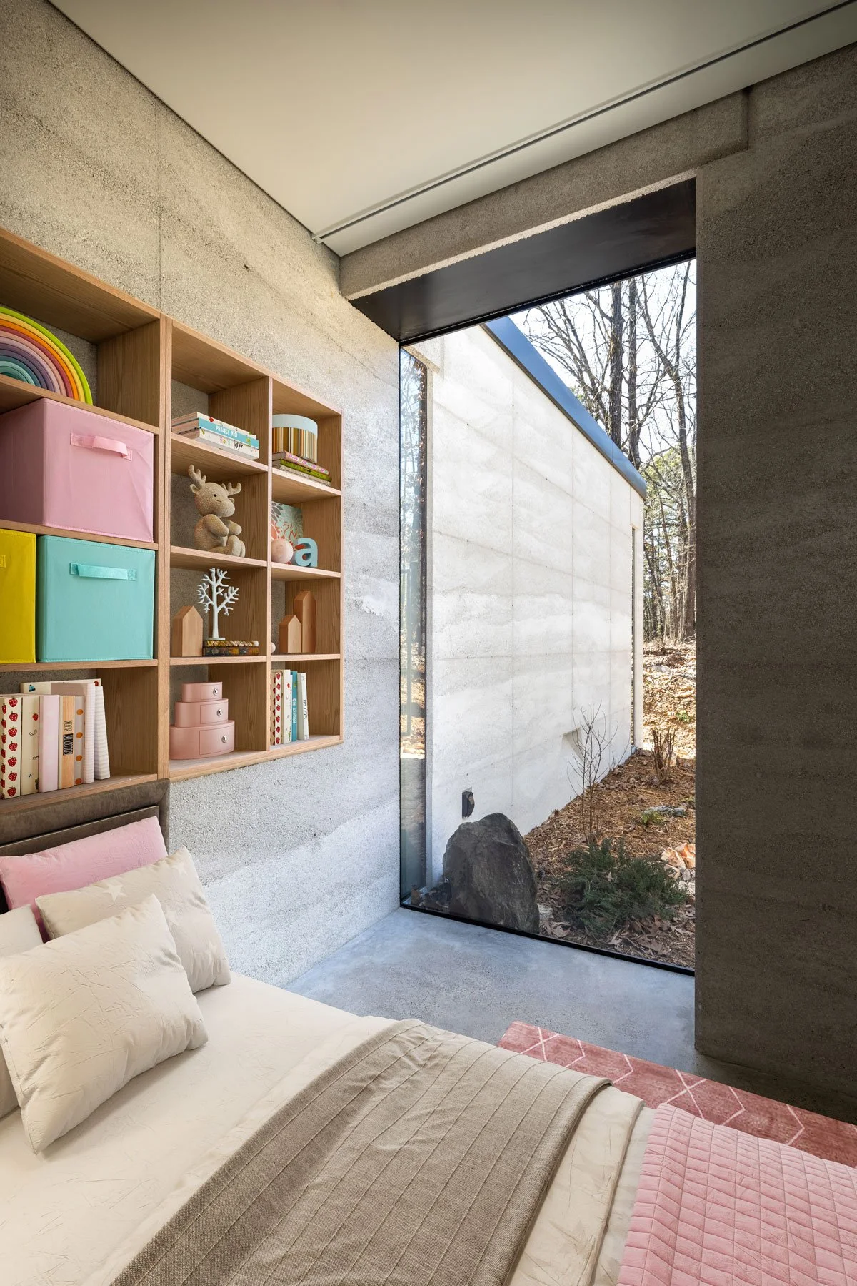 Shelving recessed into Rammed Earth wall of child’s room.