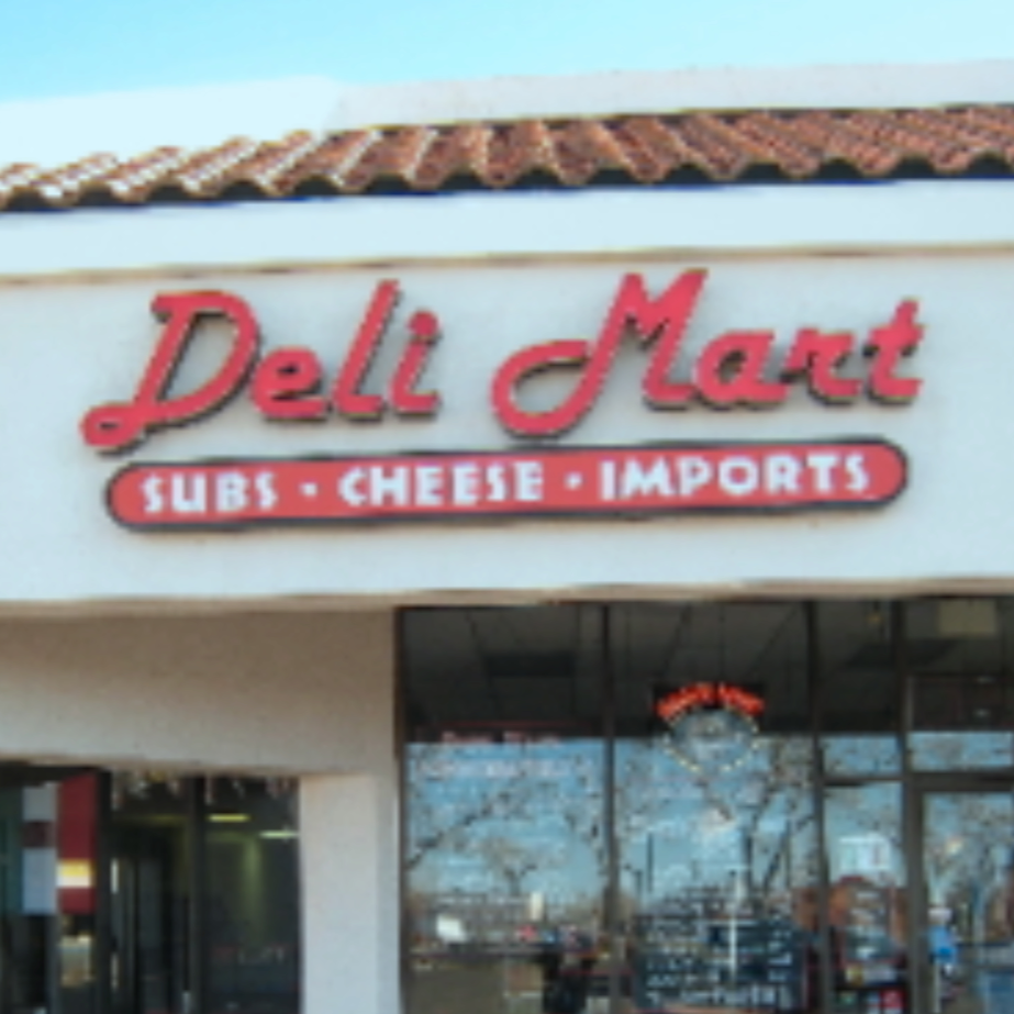 Sign of Deli Mart featuring sub, cheese, and imports on storefront