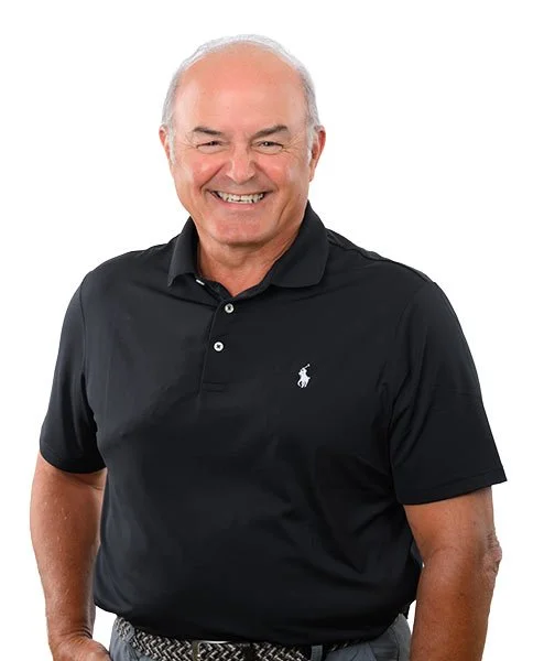 Homme âgé souriant portant un polo noir avec un logo de cheval blanc, fond blanc