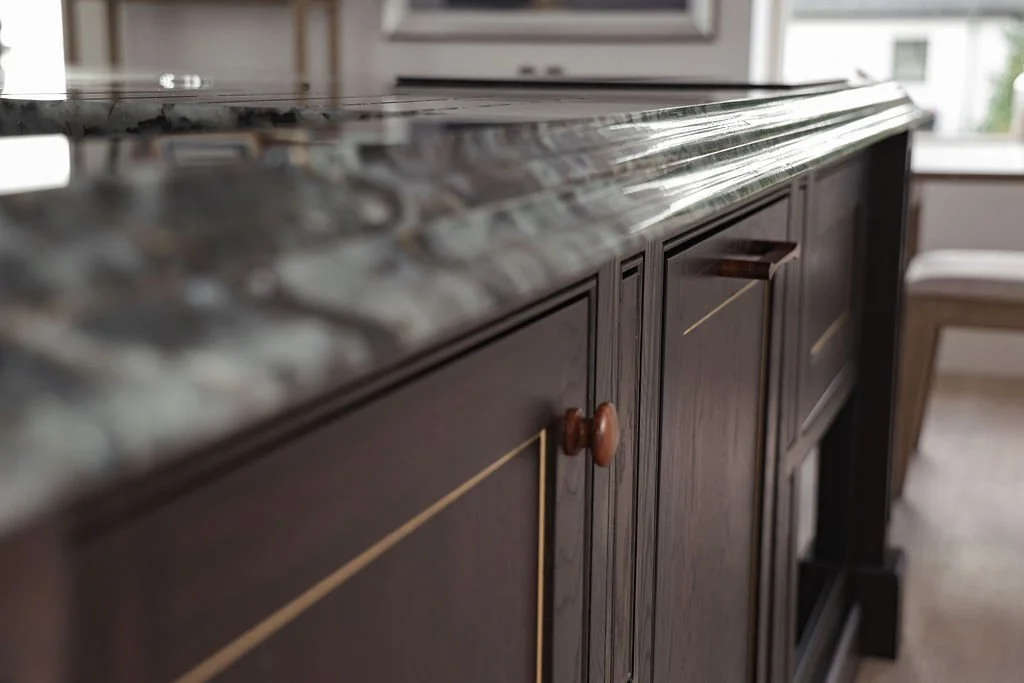 Close-up of a dark wooden kitchen cabinet with a marble countertop.