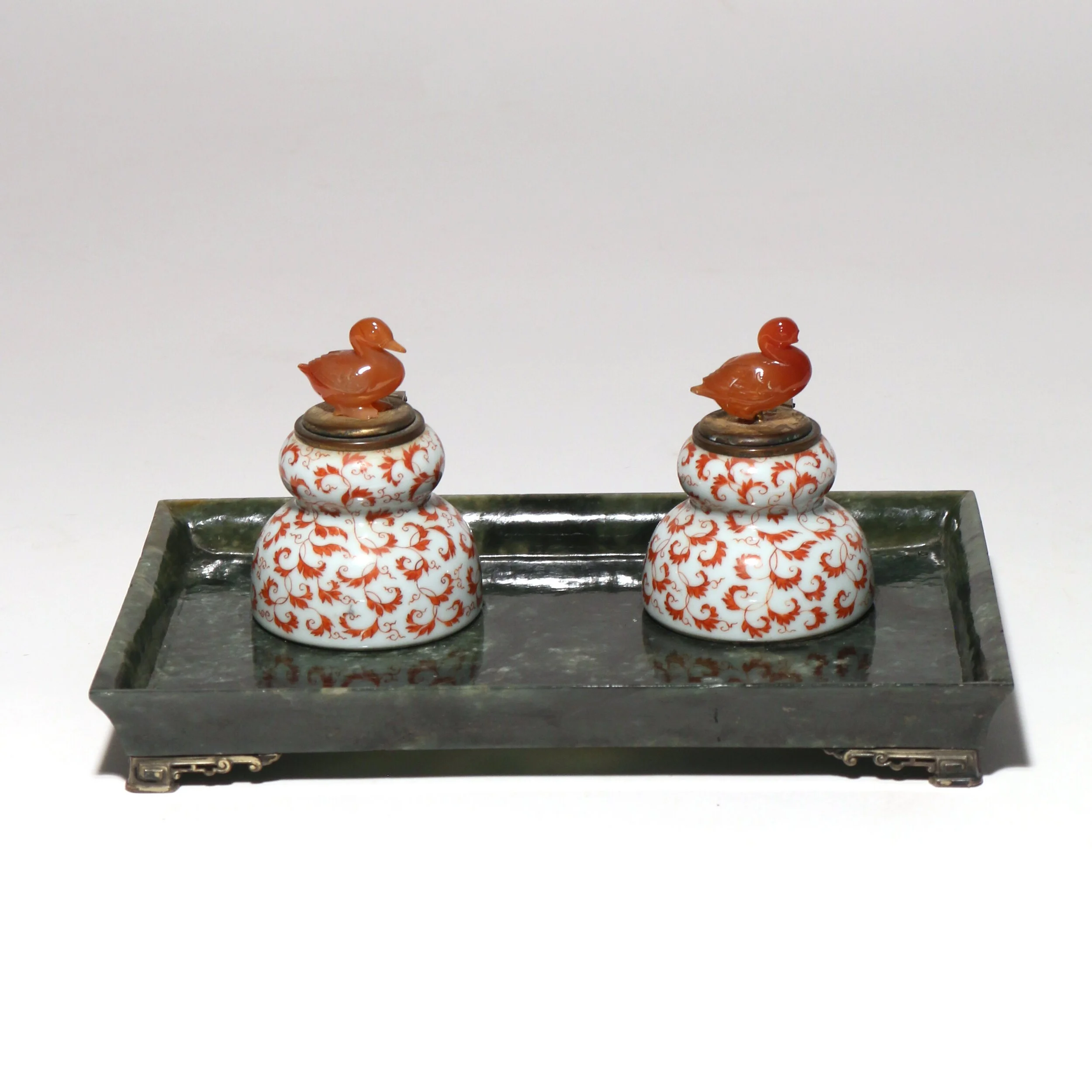 CARVED SPINACH JADE & PORCELAIN STANDISH 
having porcelain painted inkwells with carved agate bird finials 
4 x 8-3/4 x 5-1/2 in. 
Sold in March 2020 
 Hammer: $34,000