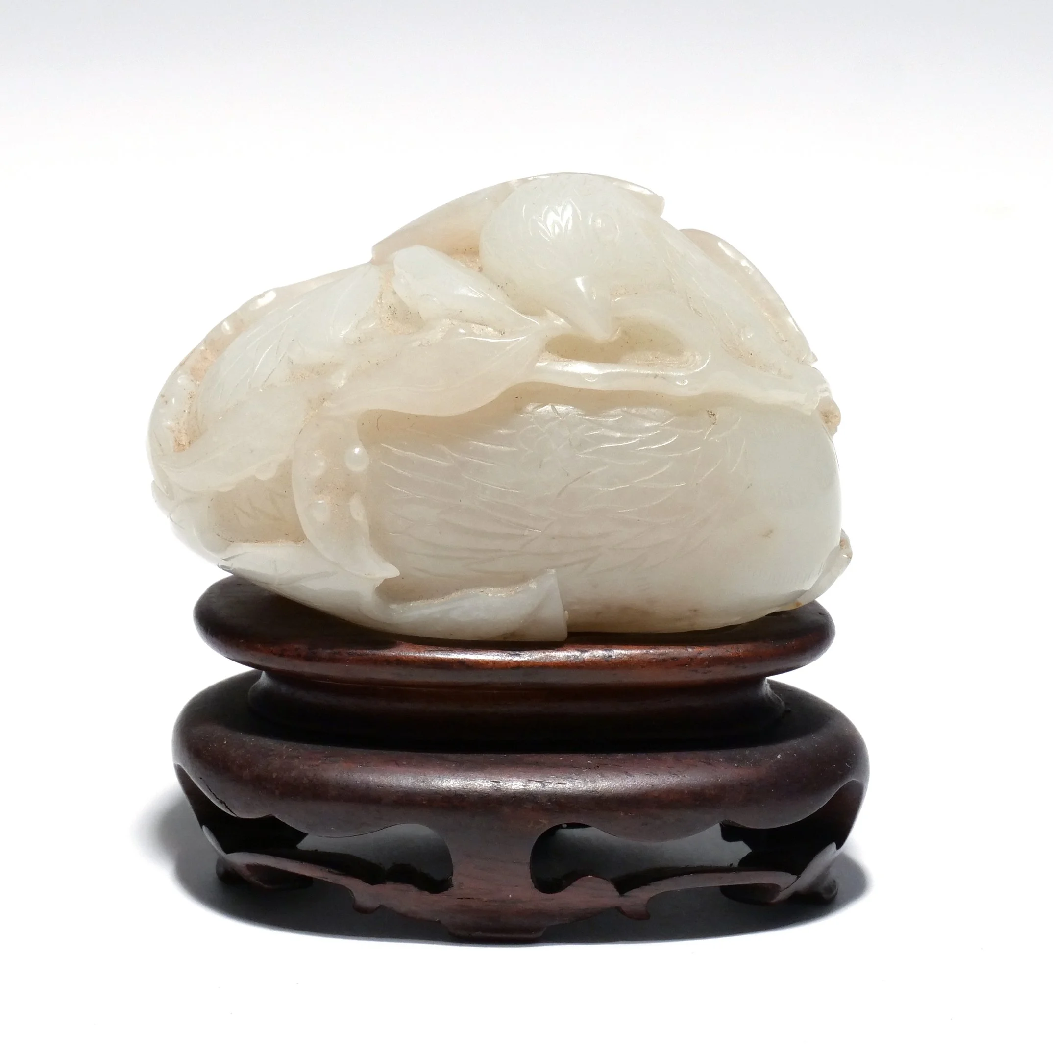 CHINESE CELADON JADE CARVED PEBBLE 
Late Qing dynasty, 19th century, depicting a bird clutching a sprig, wrapped in a leaf 
Presale Estimate: $500 - $700 
 Hammer: $4,400 
