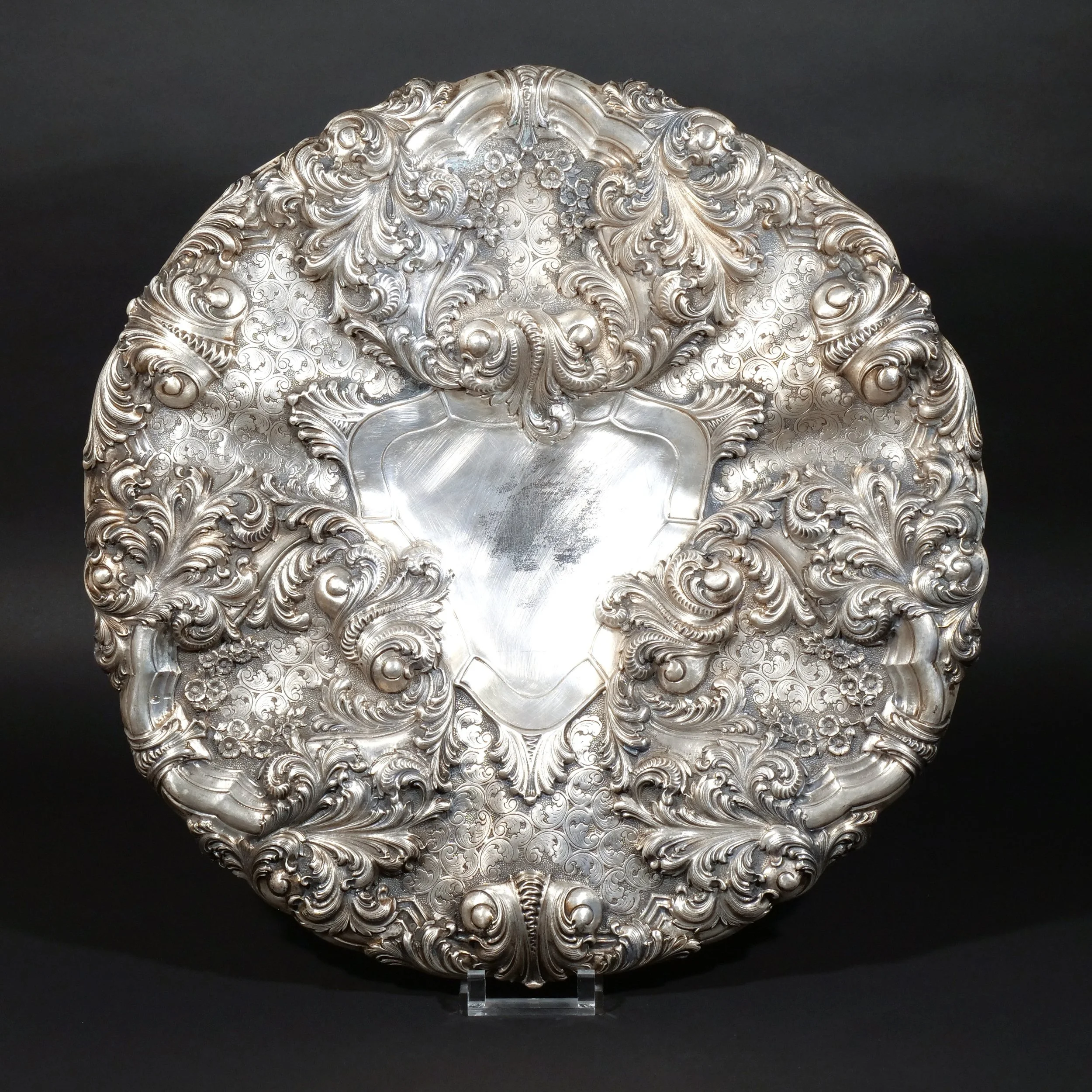 MASSIVE 25-INCH CONTINENTAL SILVER CHARGER 
Likely Portuguese, with classical foliate scrollwork en repoussé 
107 ozt 
$5,000-10,000