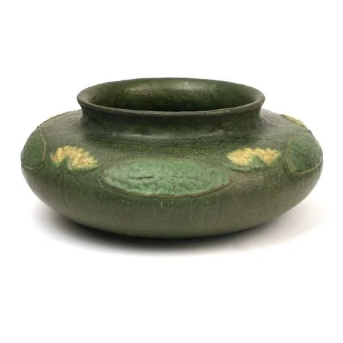 Ancient green pottery bowl with decorative yellow and green accents and a wide opening