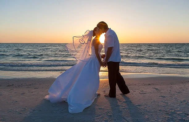 A wedding couple kissing on a Puerto Vallarta beach at sunset.