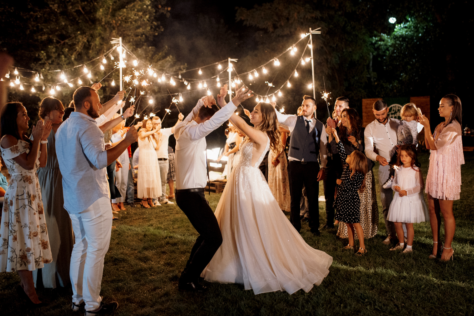 Bride and groom doing their first dance while their guests are in a circle around them.