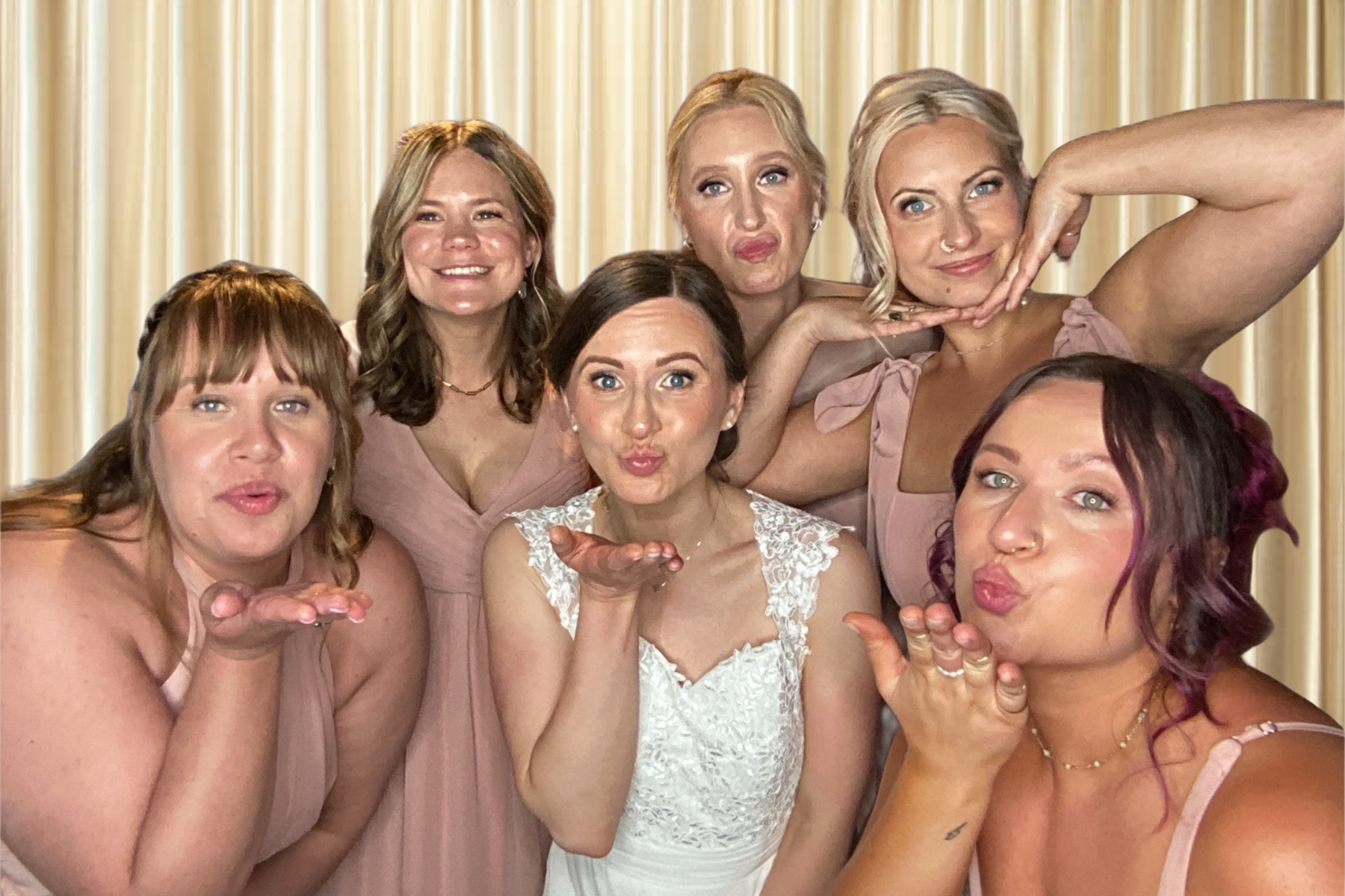 A bride with her 5 bridesmaids posing in a photo booth.