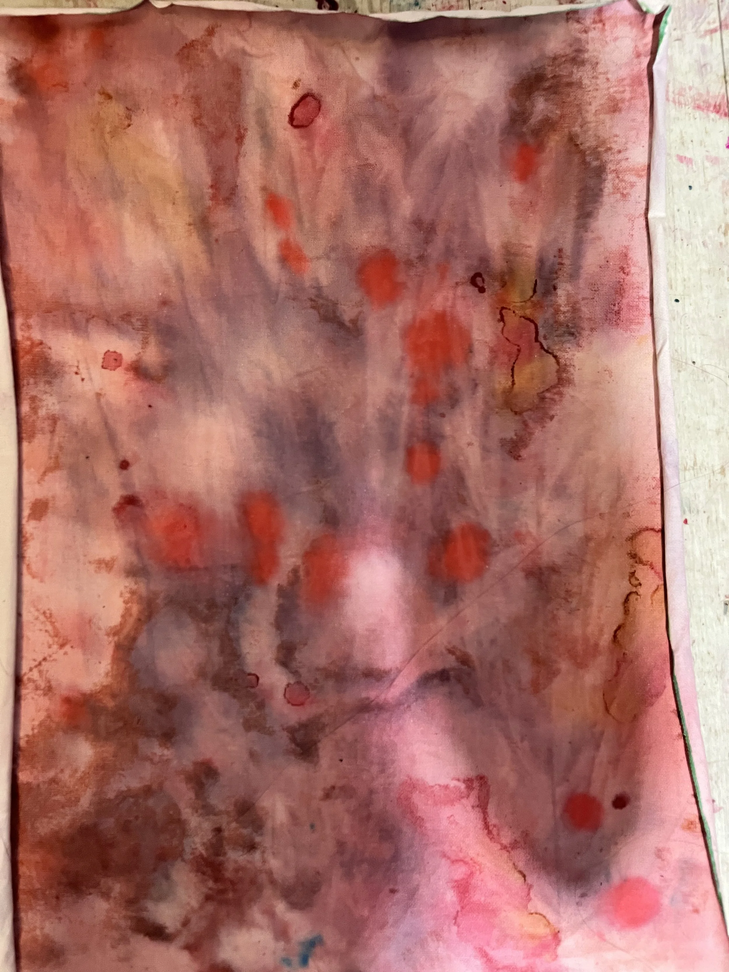 Abstract watercolor painting with shades of pink, red, purple, and brown, featuring splashes and streaks of color.