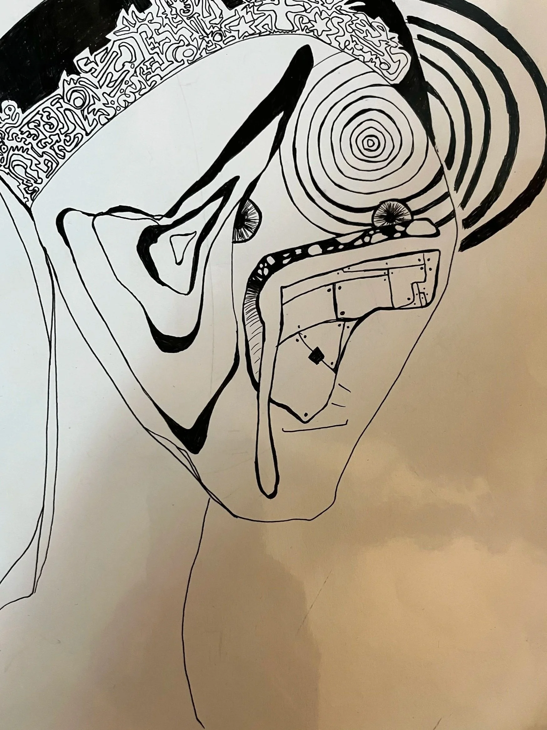 Abstract black and white line drawing of a face, with intricate patterns and concentric circles.