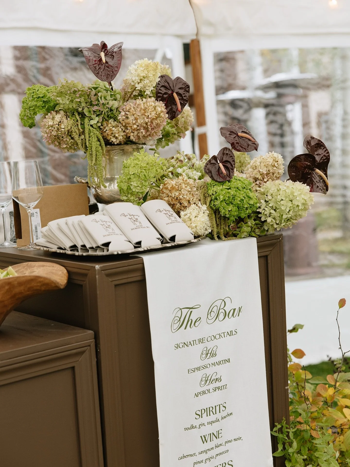 Our bar painted in chocolate brown, dressed up in moody florals and a soft fabric bar sign. What are you drinking? 

Partial Planner &amp; Coordination: @atwood.design
Photographer: @bethmacphoto
Florist &amp; Candles: @edenflowerfarm
Rentals: @atwoo