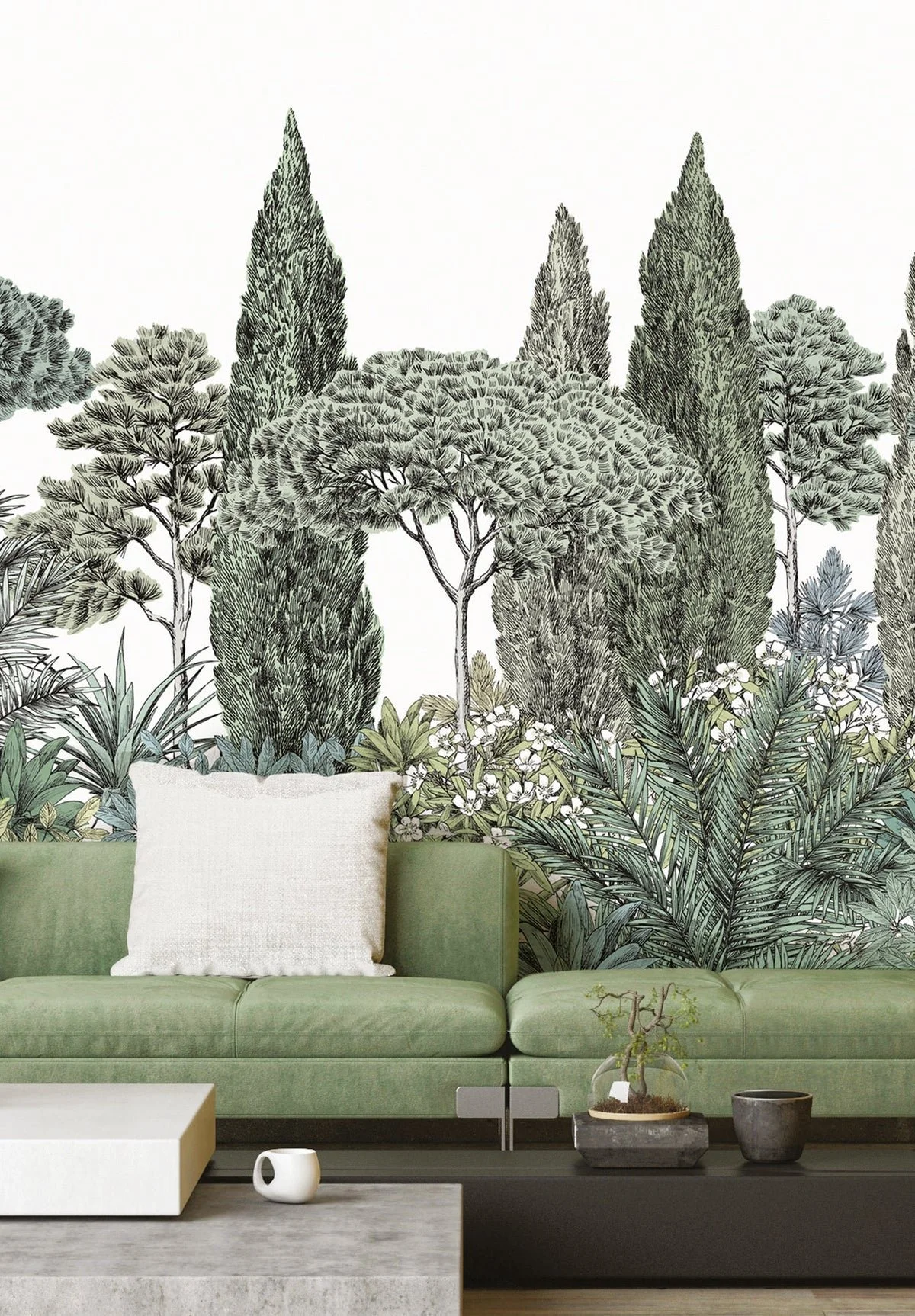 Living room with a green sofa, a white cushion, and a mural of various trees and plants on the wall behind it.