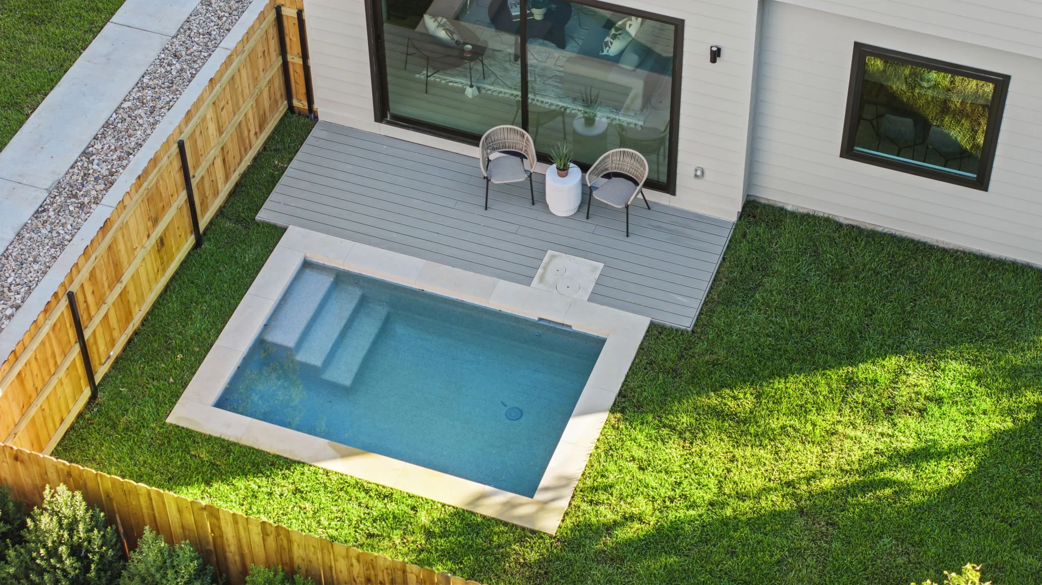 A view of the pool, deck, and garden