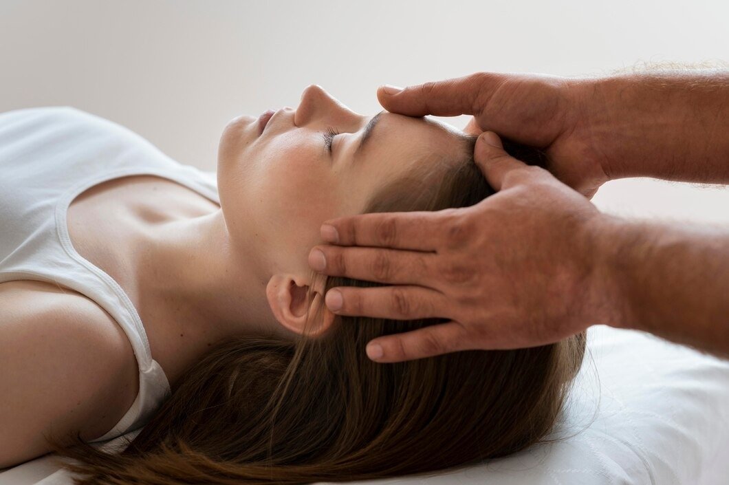 Person receiving a head massage or chiropractic adjustment while lying down.