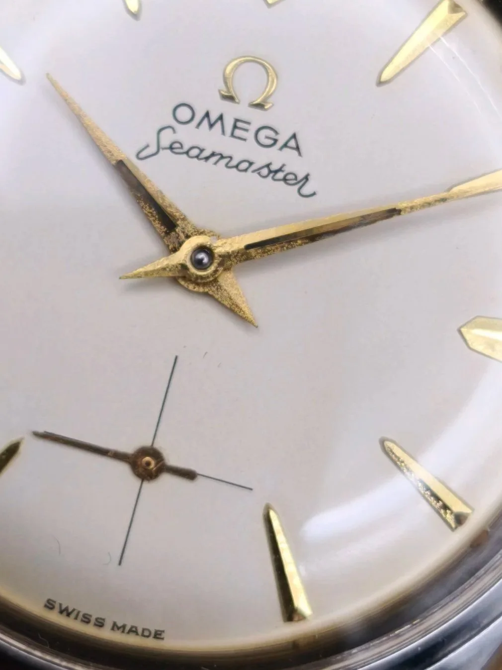 Close-up of 1958 Omega Seamaster Ranchero original cream radium dial with gold markers and hands.