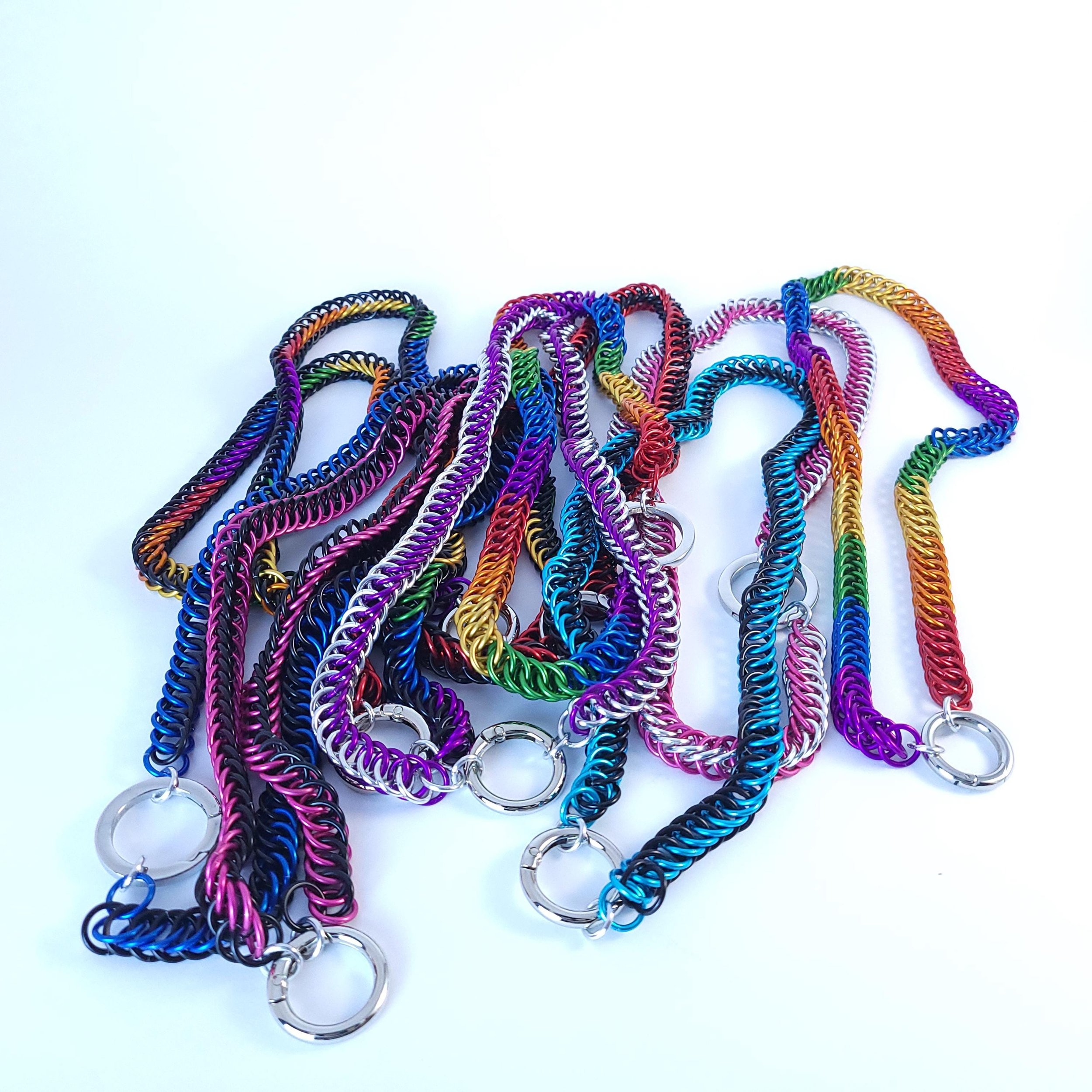 A pile of colorful Stealth Pup Collar chainmail necklaces.