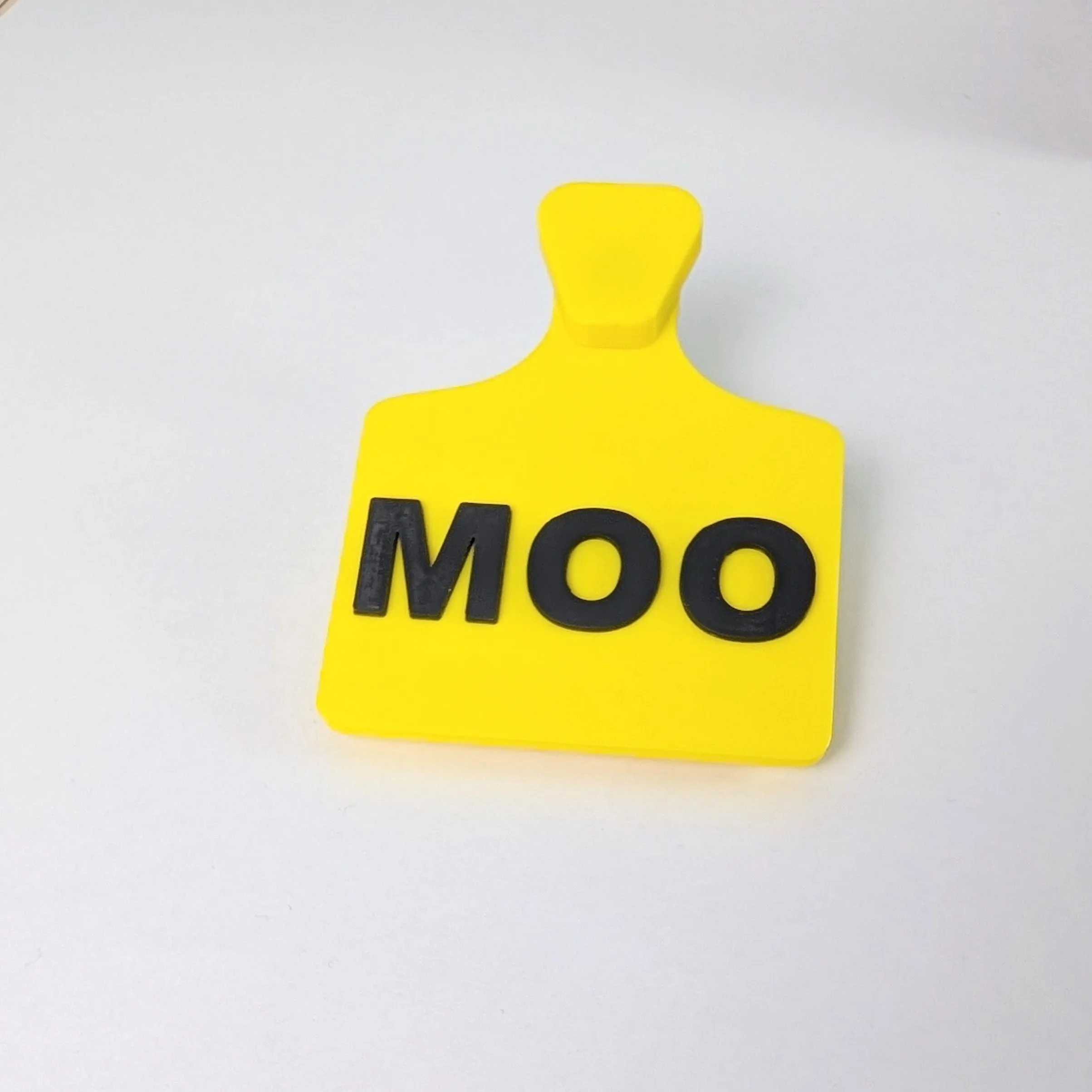 yellow fursuit ear tag with black text