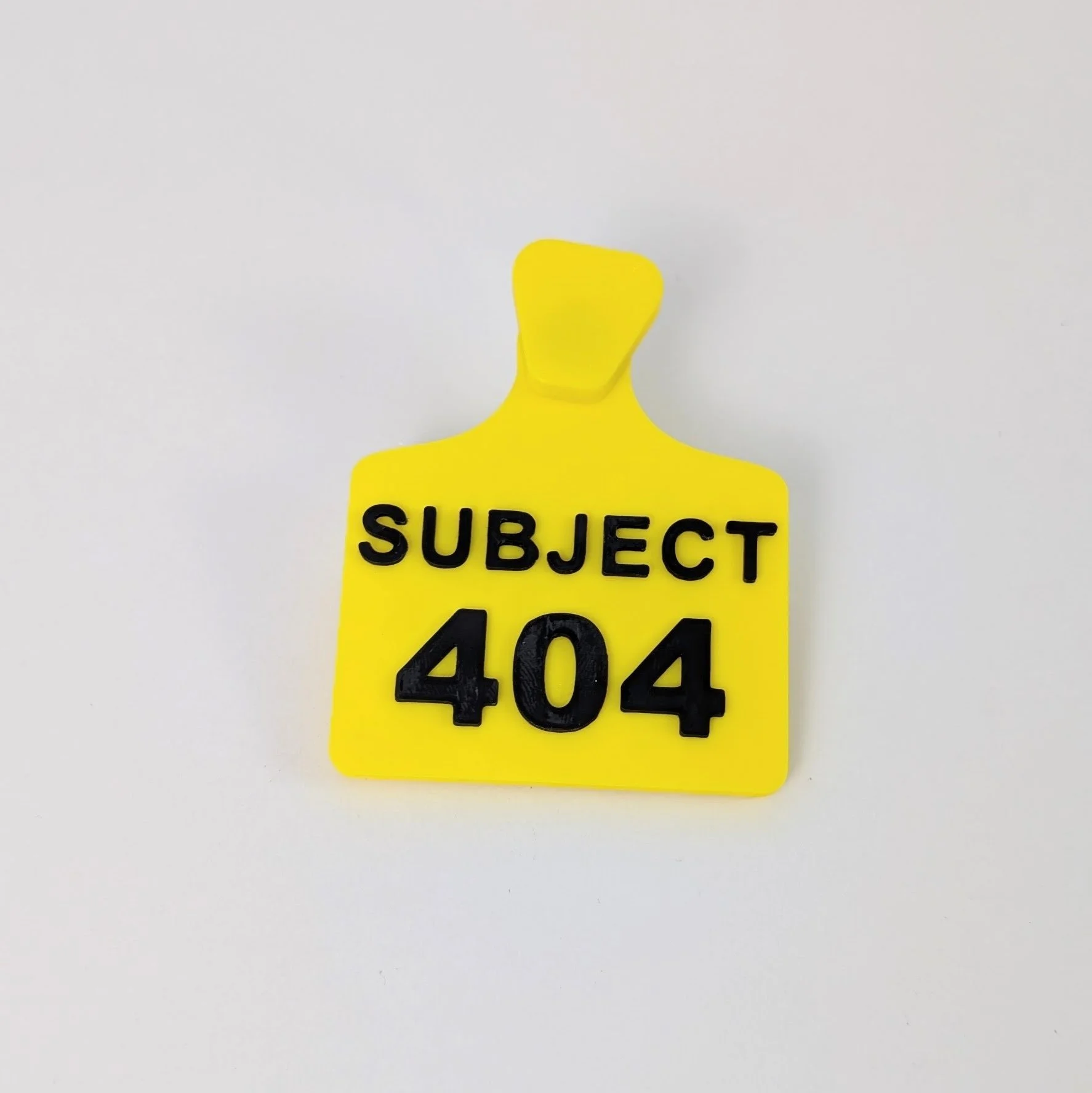 yellow fursuit ear tag with black text