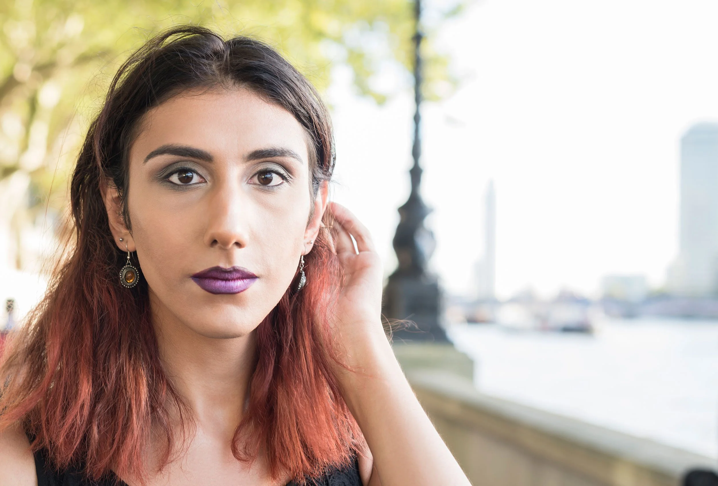 trans woman in city scene looking at camera