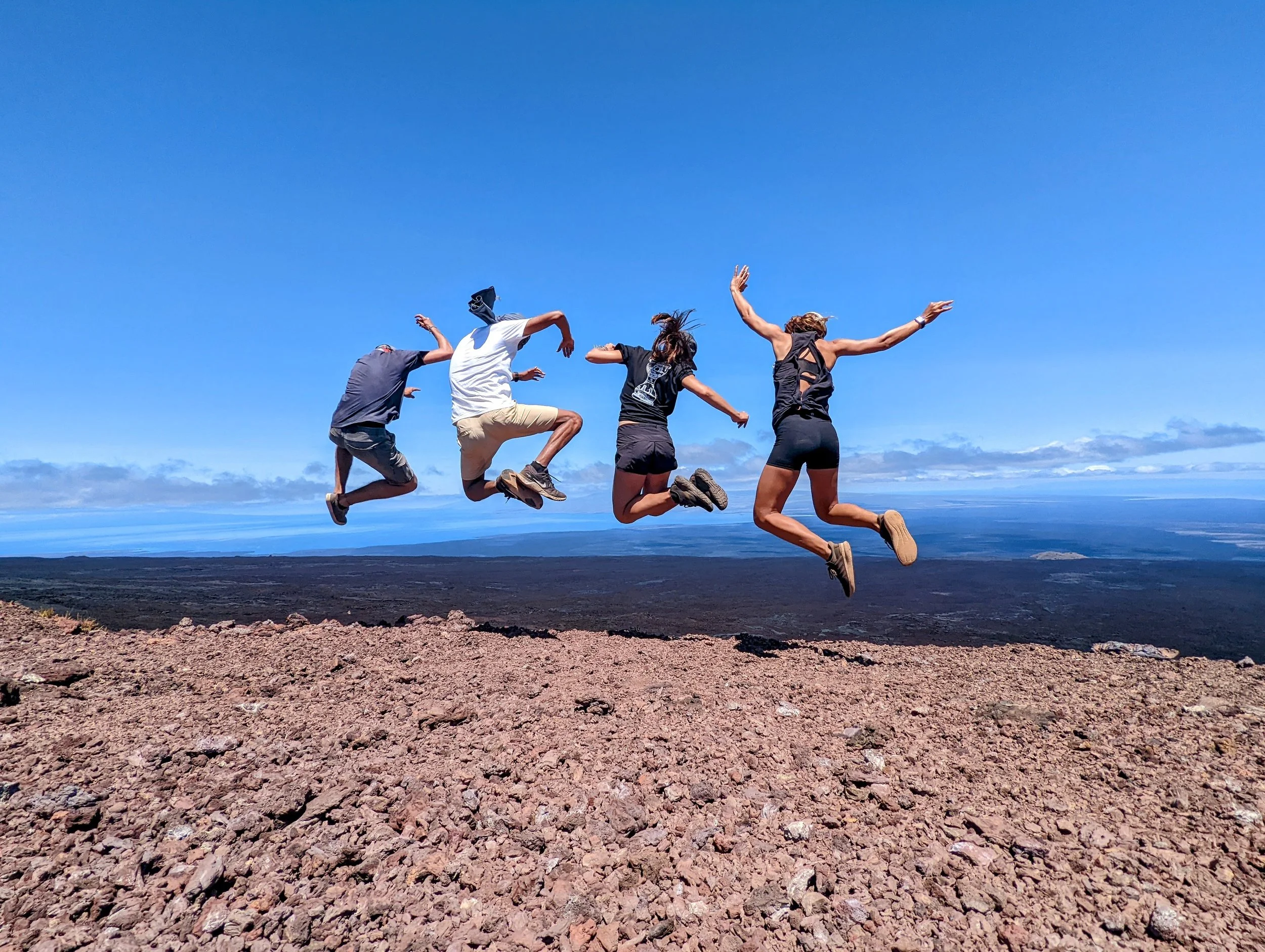 Four friends jumping in air on Sierra Negra Volcano