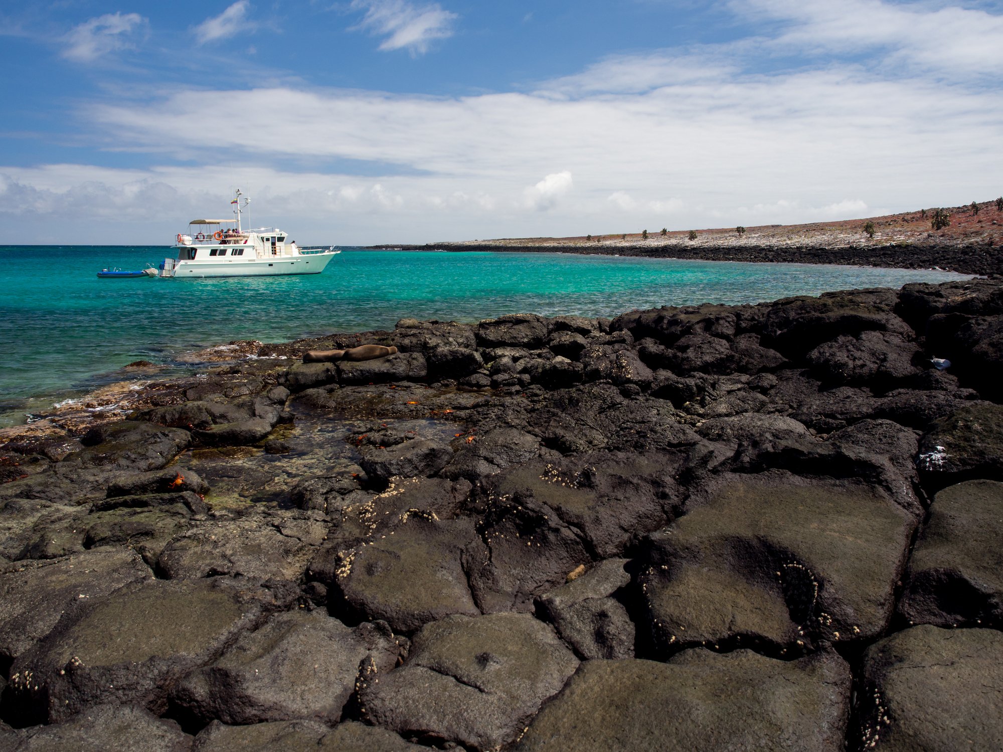 Galapagos cruise ship near volcanic island