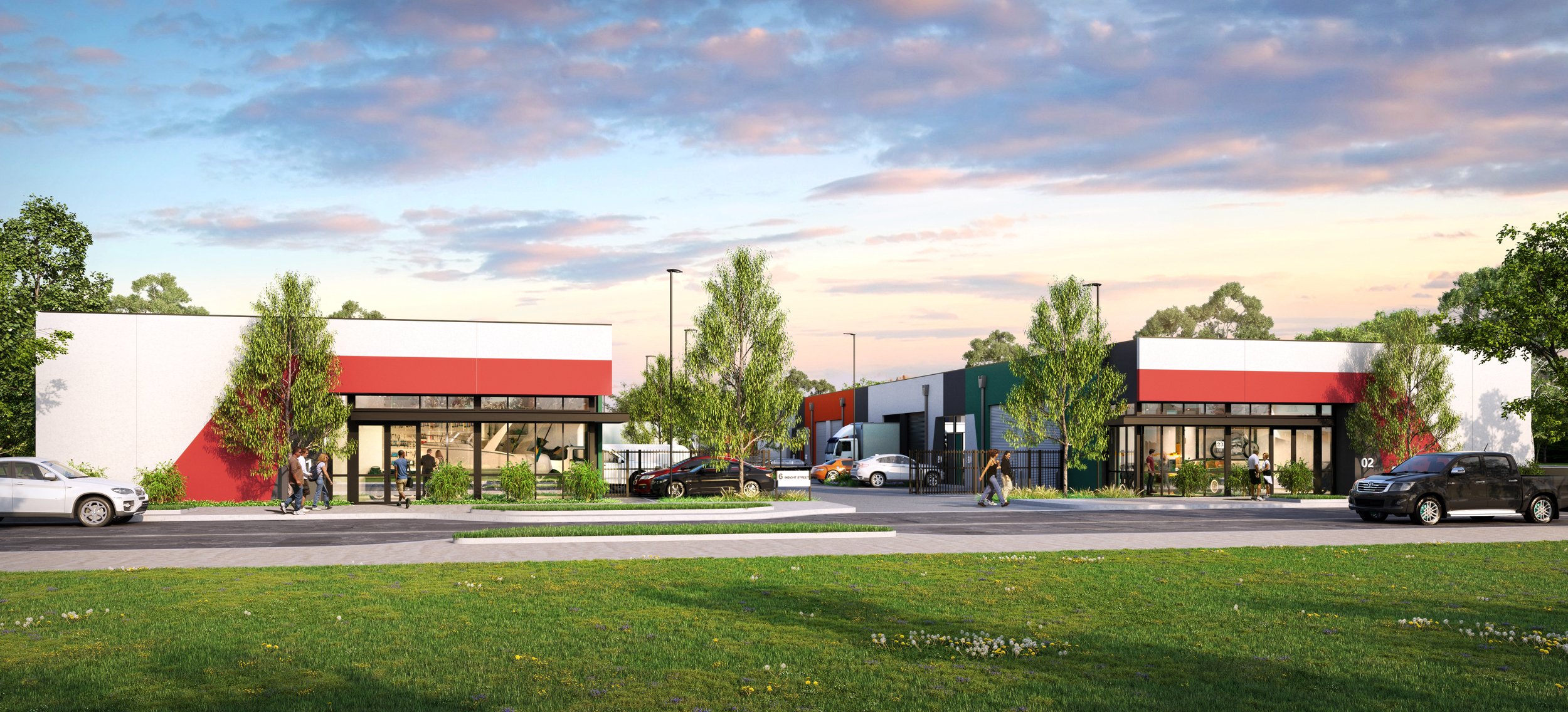 Modern commercial building complex with parking lot, trees, and people walking, under a partly cloudy sky in the late afternoon or early evening.