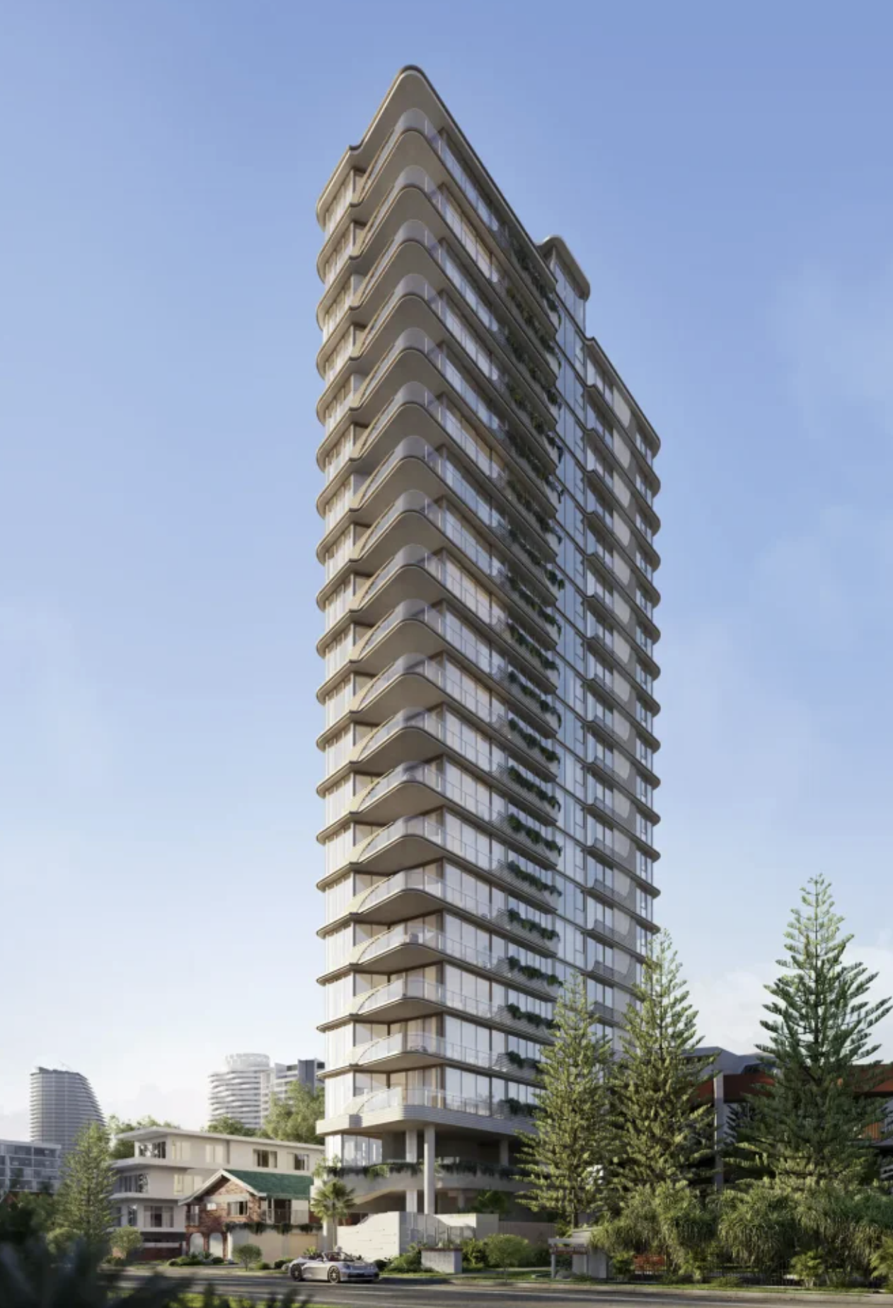 Faro Broadbeach. Modern high-rise building with illuminated windows at dusk, surrounded by trees and adjacent buildings, with a busy street and tram tracks in the foreground.