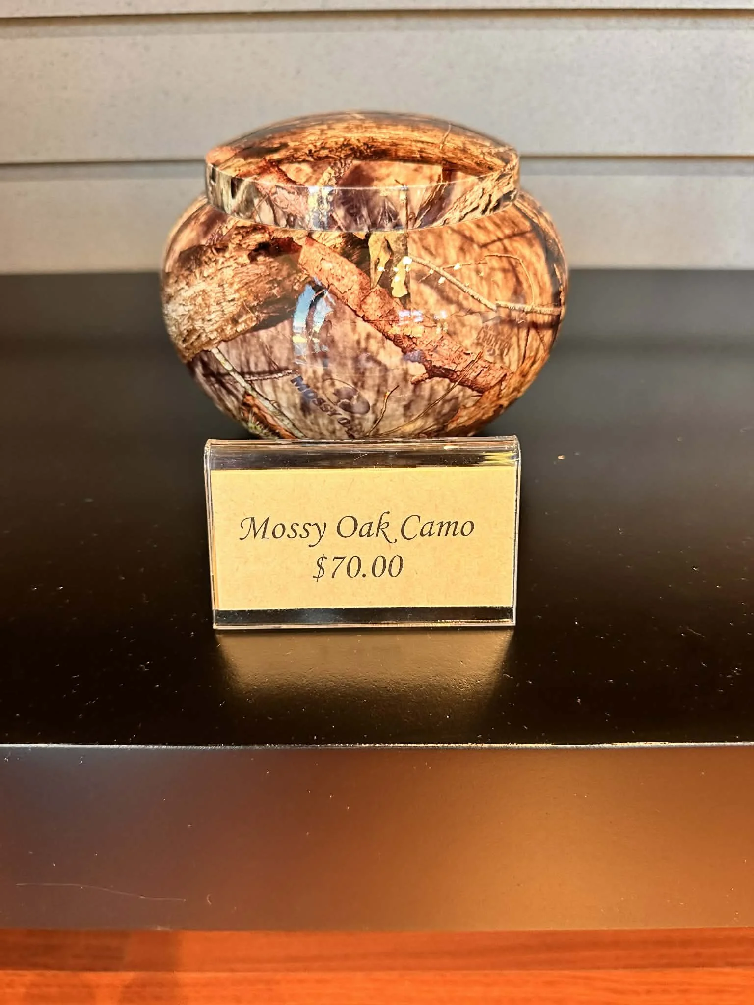 A small round jar with a camouflage pattern called Mossy Oak Camo, priced at $70.00.