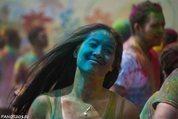 Festivalgoer covered in colorful powder during a Holi Festival of Colors celebration.