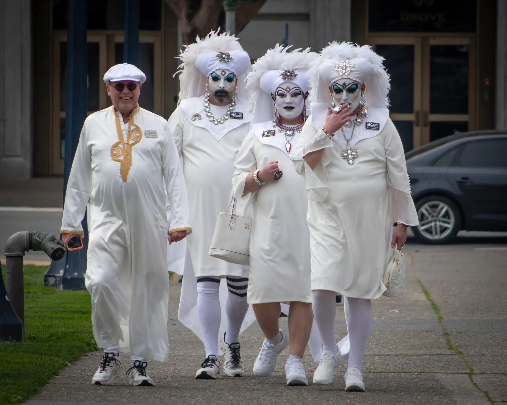 Group of Sisters of Perpetual Indulgence dressed in white walking together in San Francisco.