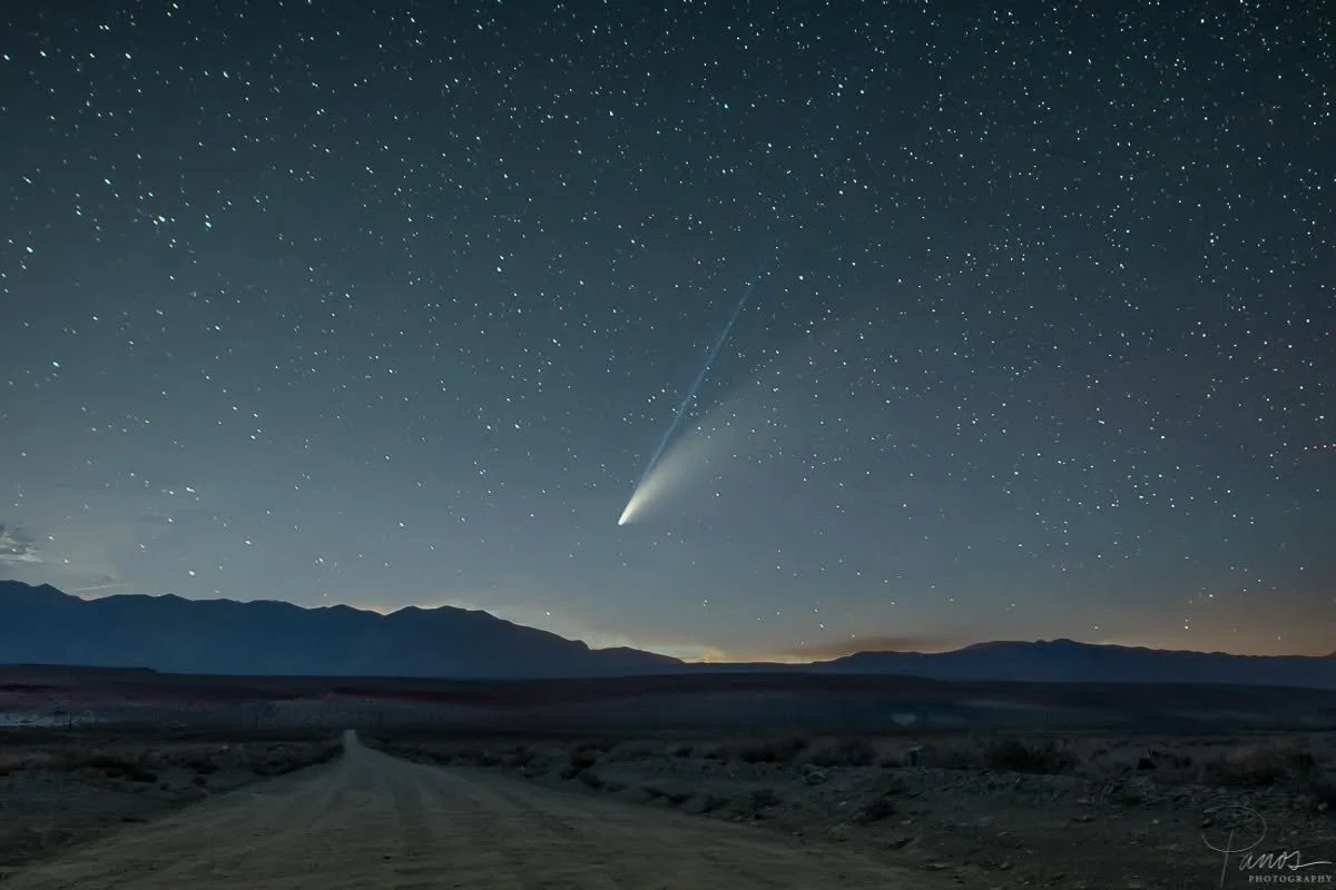 omet NEOWISE glowing above a star-filled night sky and mountain silhouette in California's Eastern Sierra.