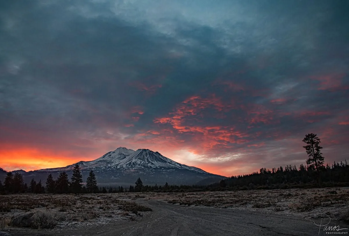 Dramatic red and orange sunrise behind Mount Shasta in Northern California.
