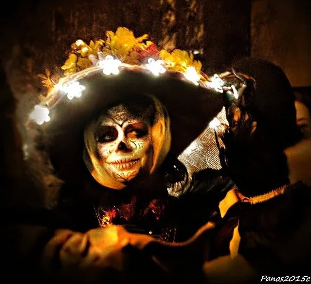 Día de los Muertos participant with skull face paint illuminated by candlelight in San Francisco.